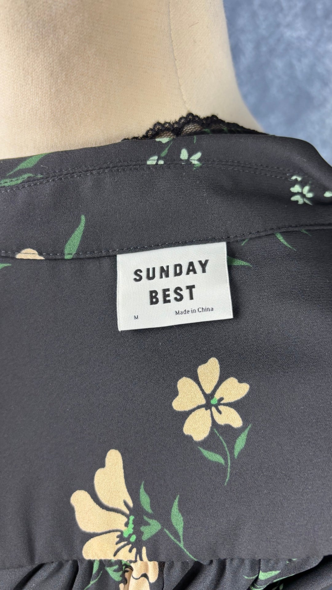Chemisier noir floral avec détail de dentelle fine, Sunday Best, taille medium. Vue de l'étiquette.