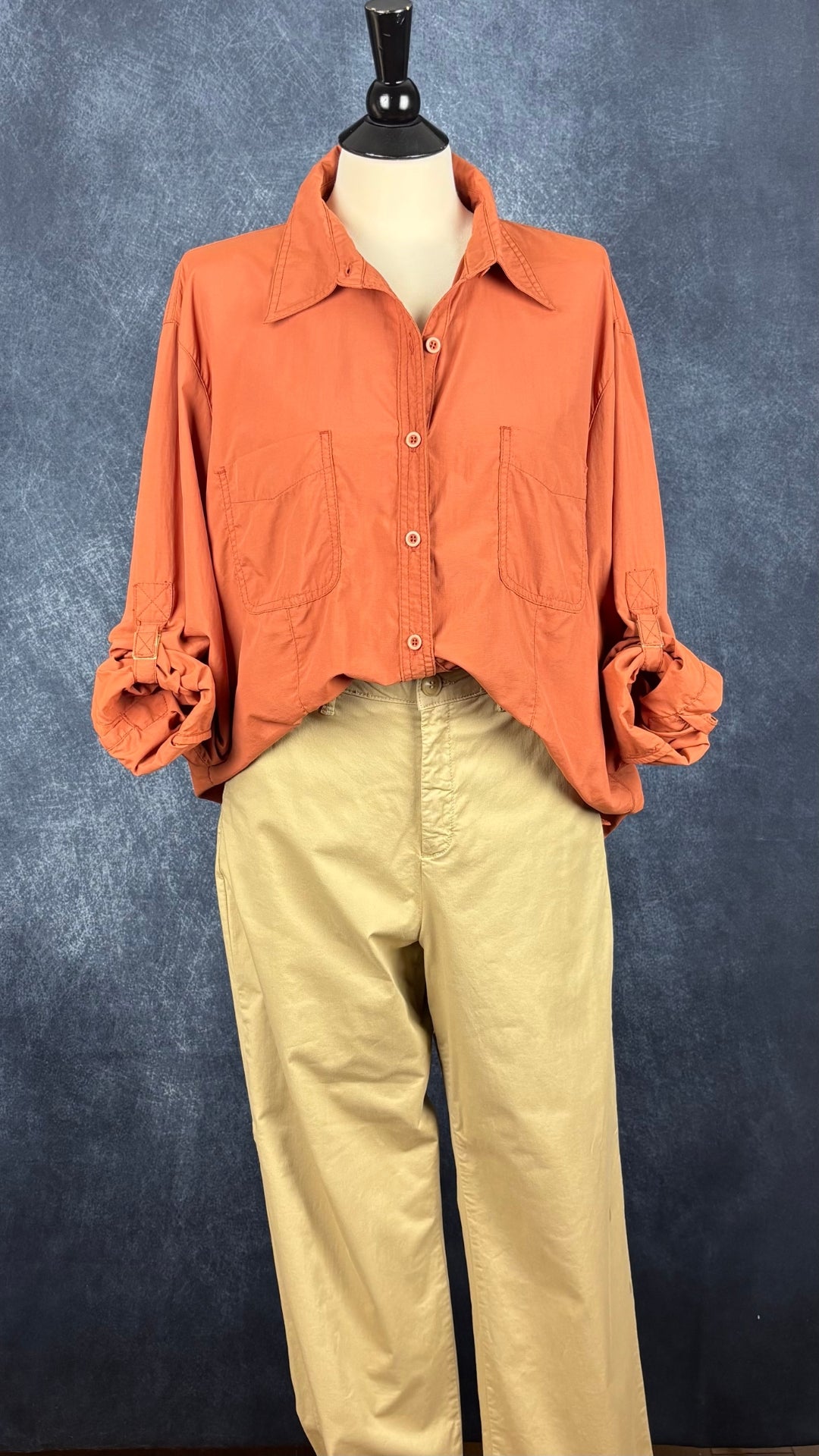 Chemisier orange brulé léger en nylon style sport, parfait pour voyager, Tilley, taille estimée à xl. Vue de l'agencement avec le pantalon beige Part Two.