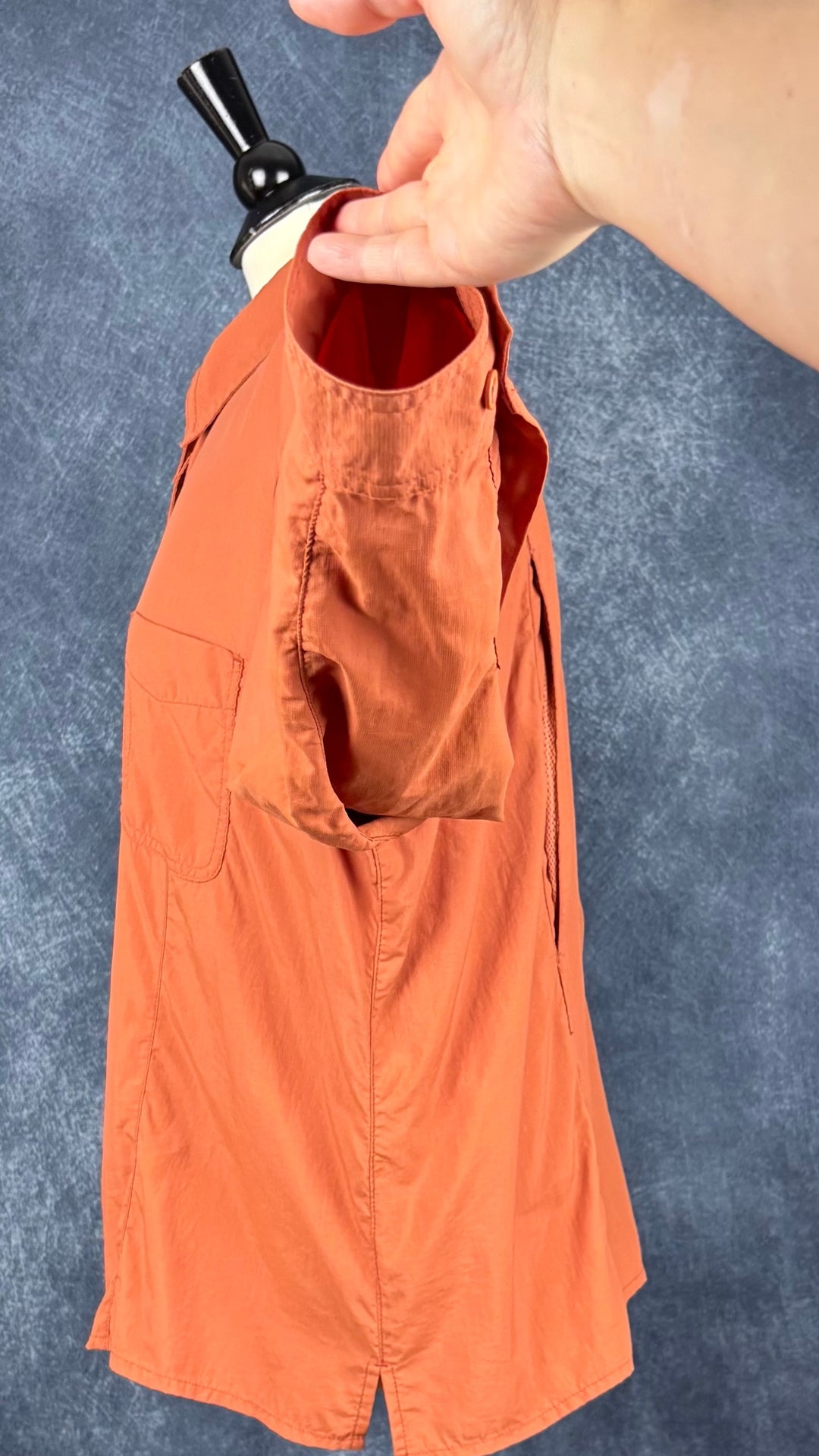 Chemisier orange brulé léger en nylon style sport, parfait pour voyager, Tilley, taille estimée à xl. Vue de côté, manche relevée.