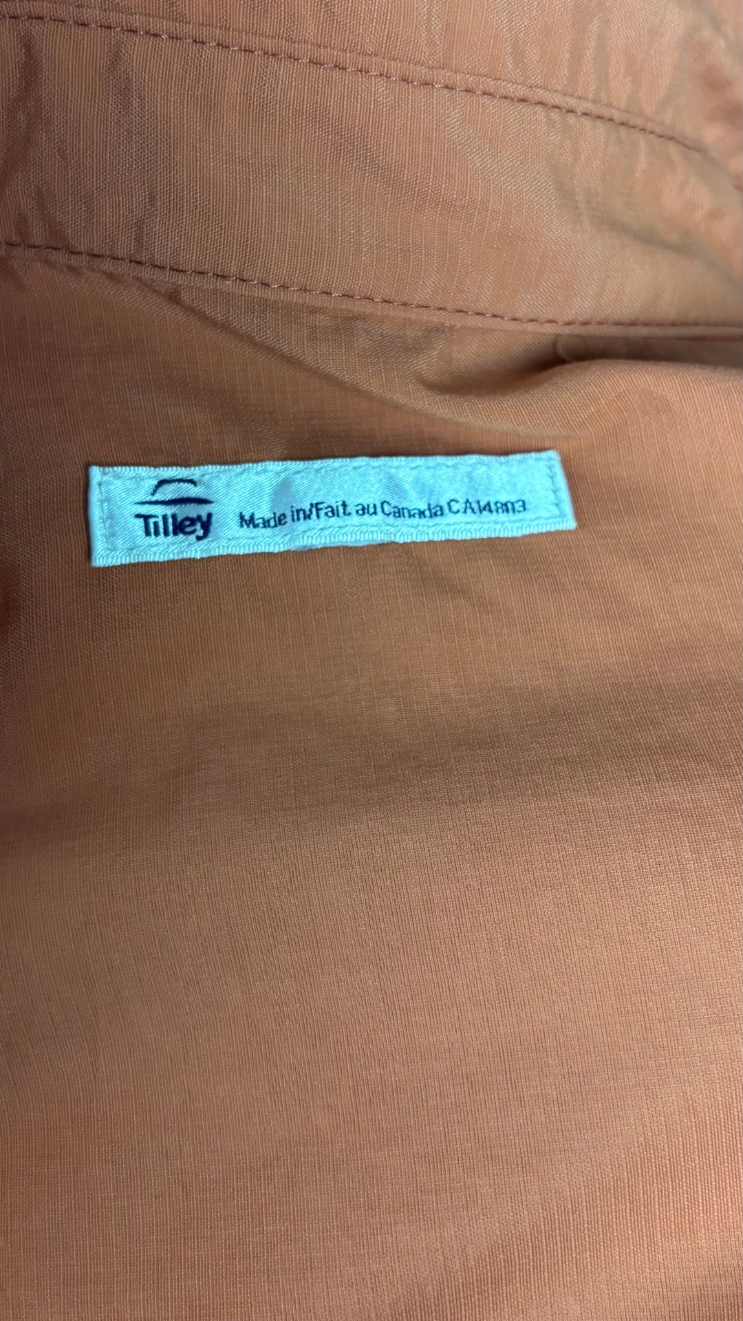 Chemisier orange brulé léger en nylon style sport, parfait pour voyager, Tilley, taille estimée à xl. Vue de l'étiquette.