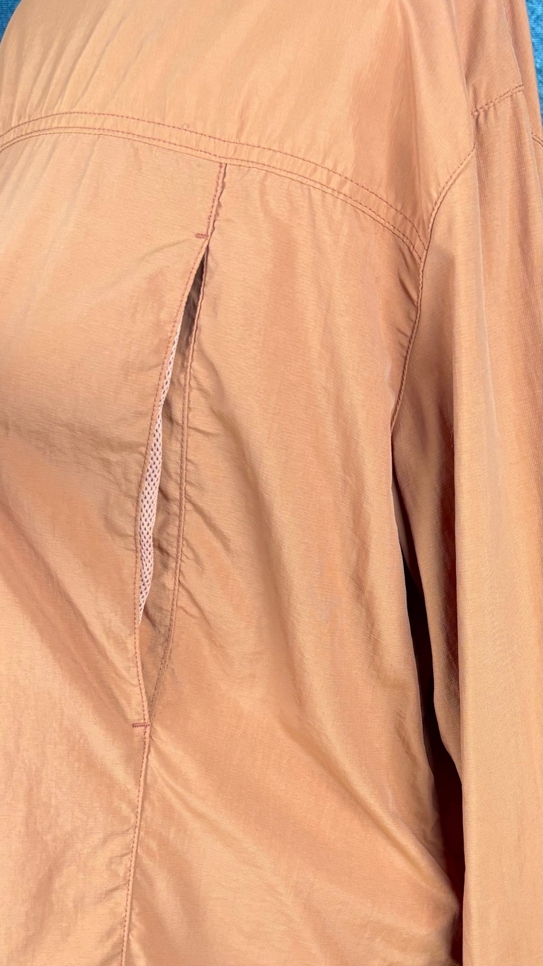Chemisier orange brulé léger en nylon style sport, parfait pour voyager, Tilley, taille estimée à xl. Vue de près des fentes d'aération au dos.