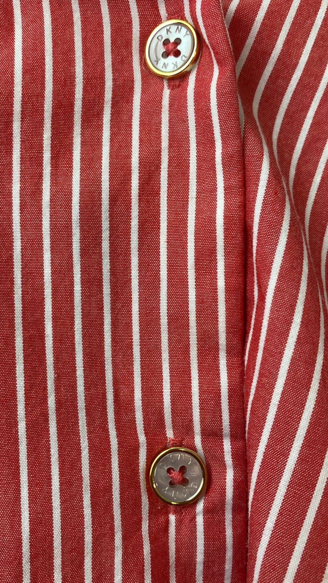 Chemisier rouge rose à rayures DKNY, taille medium. Vue de près des boutons et du tissu.