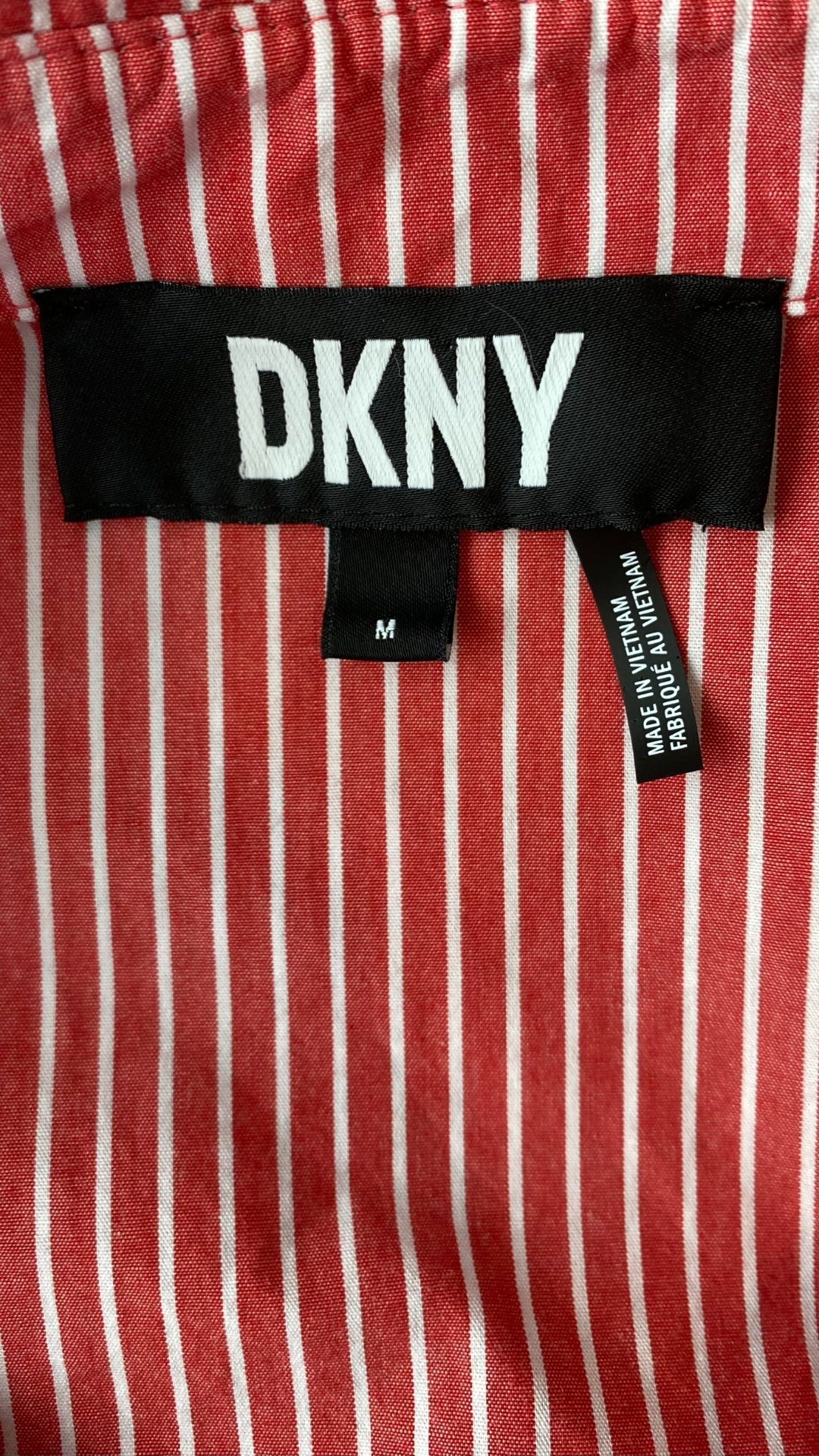 Chemisier rouge rose à rayures DKNY, taille medium. Vue de l'étiquette de marque.