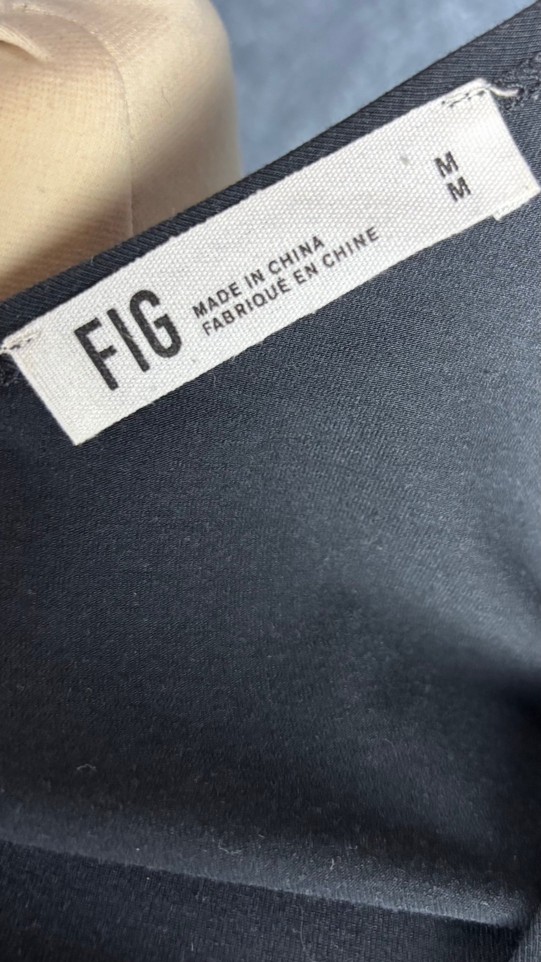 Combinaison noire courte confortable et extensible, Fig, taille medium. Vue de l'étiquette.
