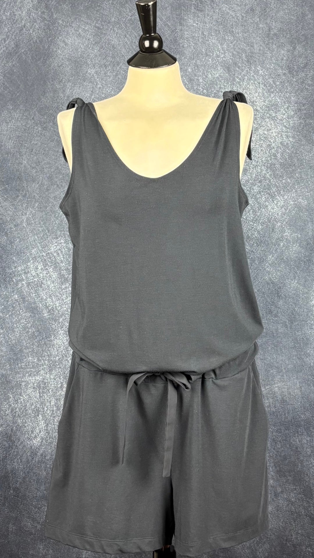 Combinaison noire courte confortable et extensible, Fig, taille medium. Vue de face, avec la taille resserrée.