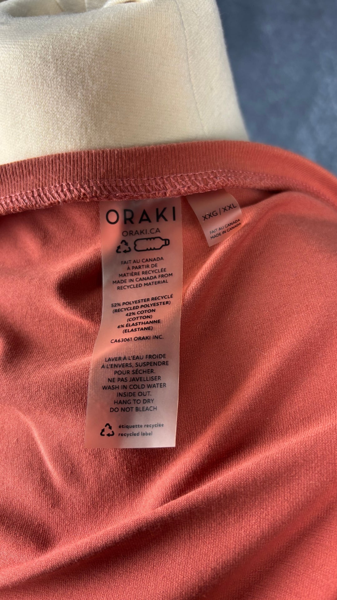 Combinaison short orangée à manches longues Oraki, taille xxl. Vue de l'étiquette.