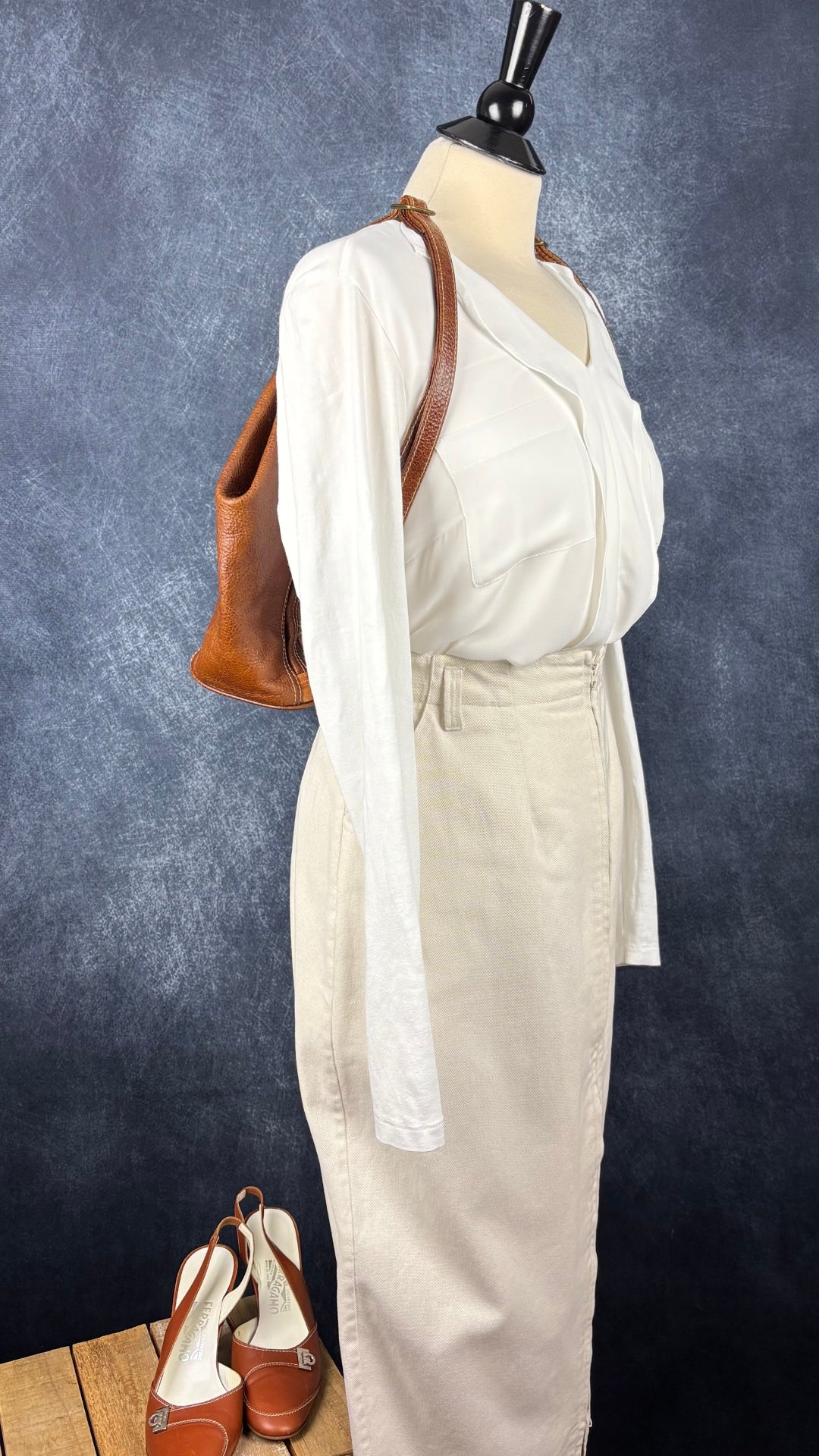 Escarpin à bride arrière brun tan en cuir Salvatore Ferragamo, talle 8 B. Vue de l'agencement avec la jupe Harly Jae, la blouse Olsen et le sac à dos Matteo Mio.