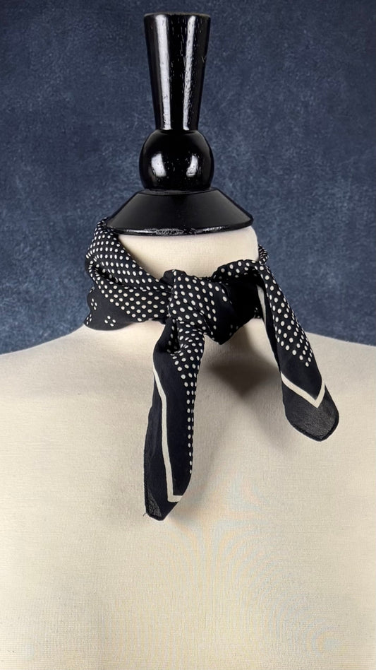 Foulard en soie carré à pois noir et crème. Vue du foulard autour du cou du mannequin.