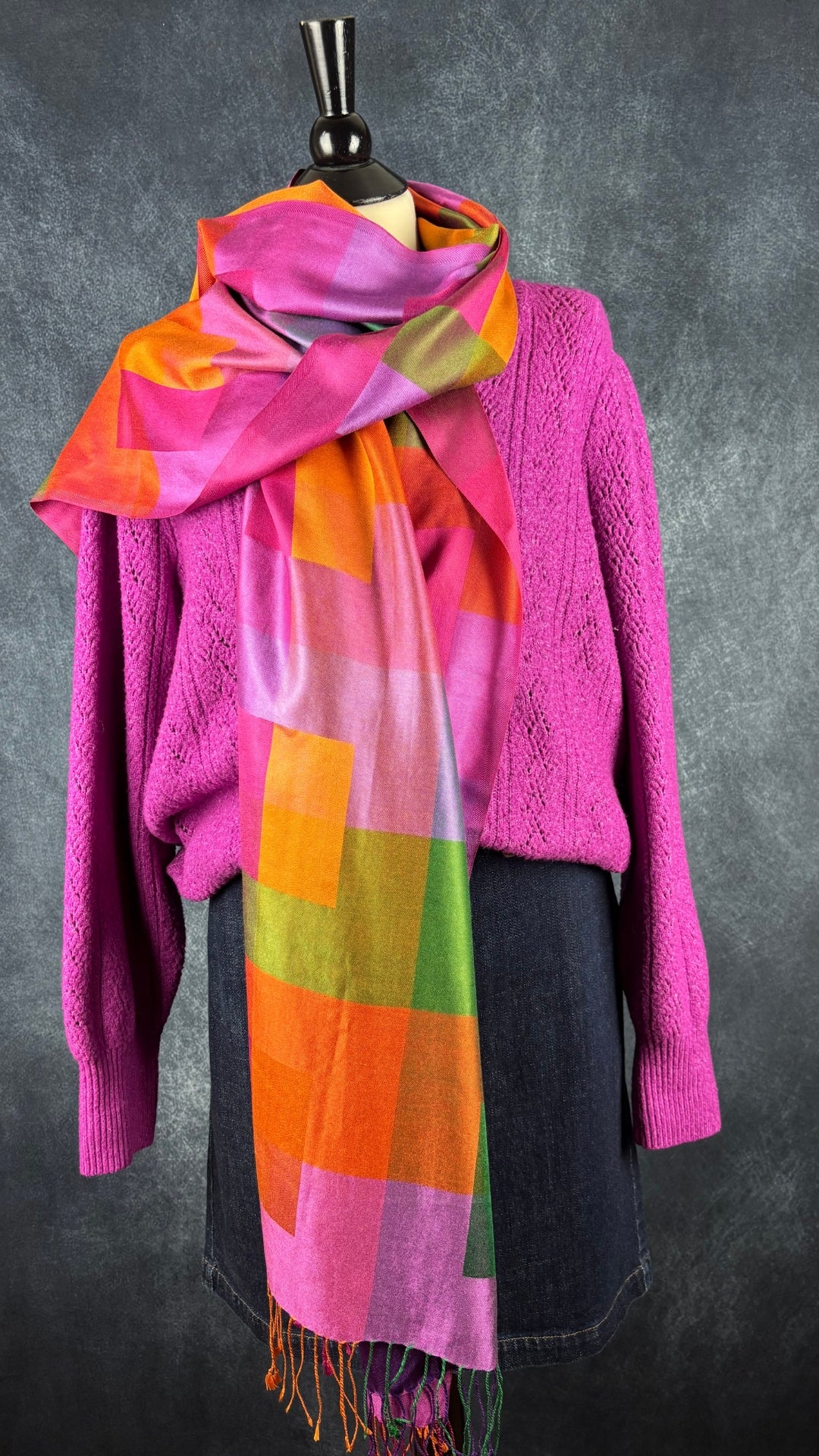Grand foulard rectangulaire en twill de soie colorée. Vue de l'agencement avec le tricot rose Joie et la jupe en denim foncé Lauren Ralph Lauren.