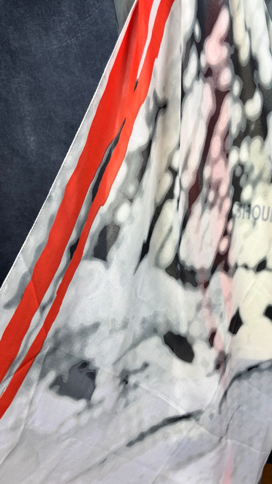 Grand foulard carré gris et orangé femme fatale. Vue du tissu, de près.