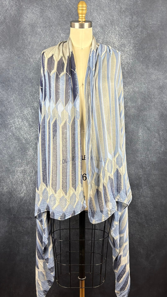 Foulard fin à motifs géométriques gris, bleu doux, bleu denim, marine Sandwich, grand rectangle. Vue du foulard déposé sur les épaules du mannequin.