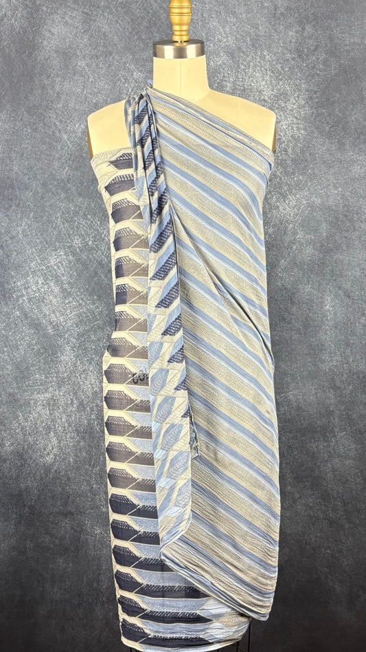 Foulard fin à motifs géométriques gris, bleu doux, bleu denim, marine Sandwich, grand rectangle. Vue du foulard en guise de robe de plage sur le mannequin.