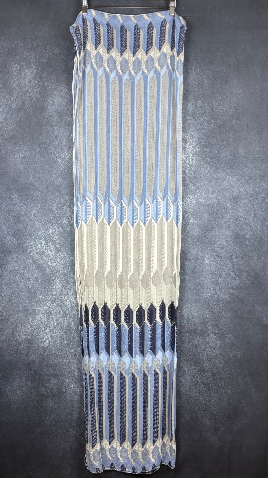 Foulard fin à motifs géométriques gris, bleu doux, bleu denim, marine Sandwich, grand rectangle. Vue du foulard plié en deux sur un cintre, déployé sur toute sa longueur.
