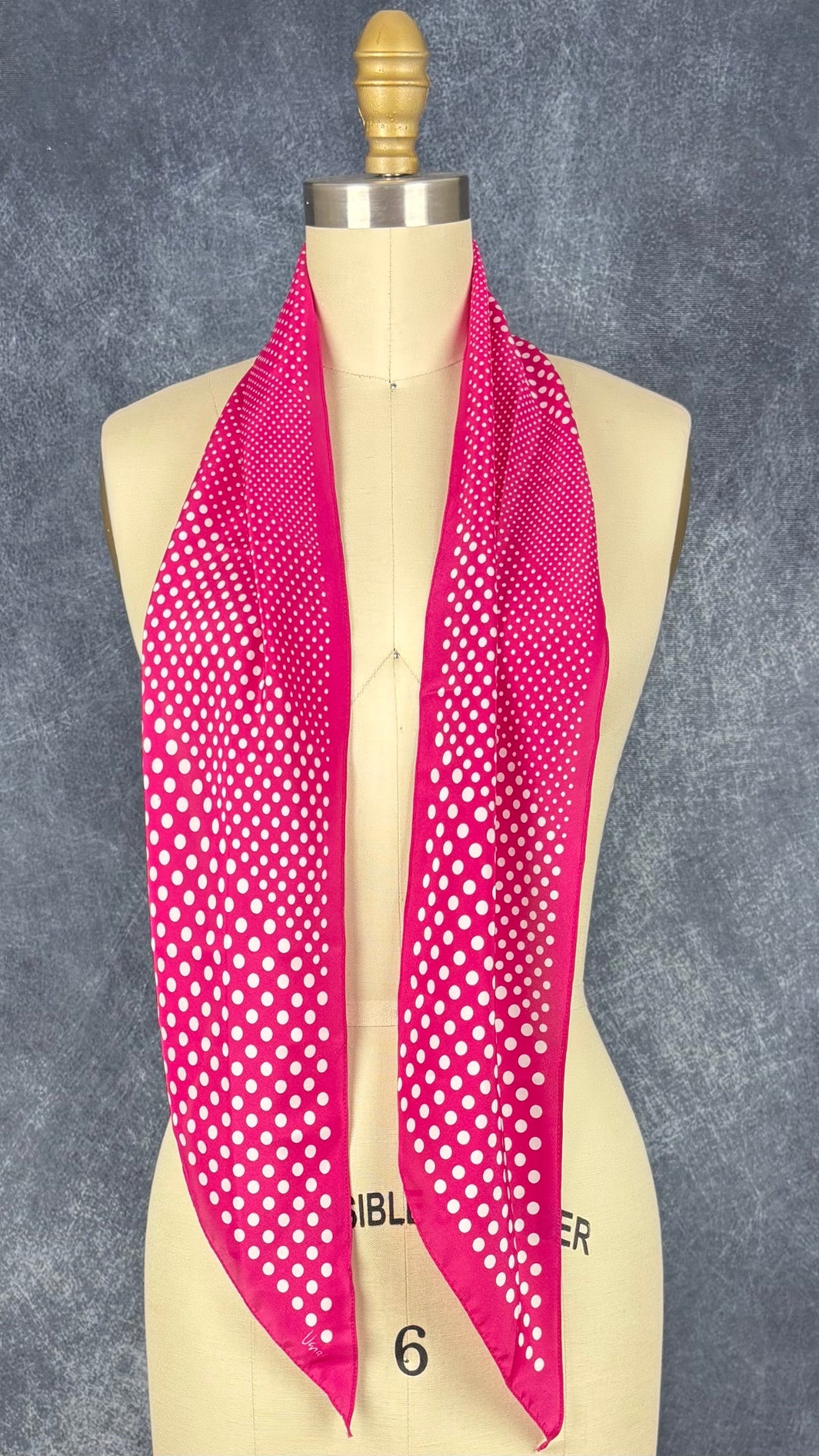 Foulard rose étroit à extrémités en pointe à pois blanc Vera. Vue du foulard déposé sur les épaules du mannequin.