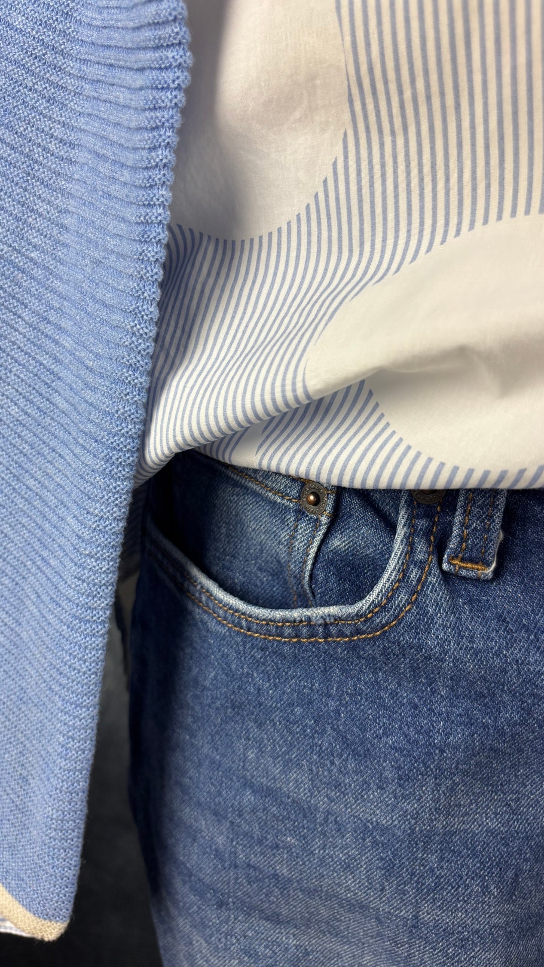 Jeans coupe étroite délavage bleu moyen Yoga Jeans, taille 29. Vue de près de l'agencement avec le chemisier Brax et le tricot de coton bleu doux.