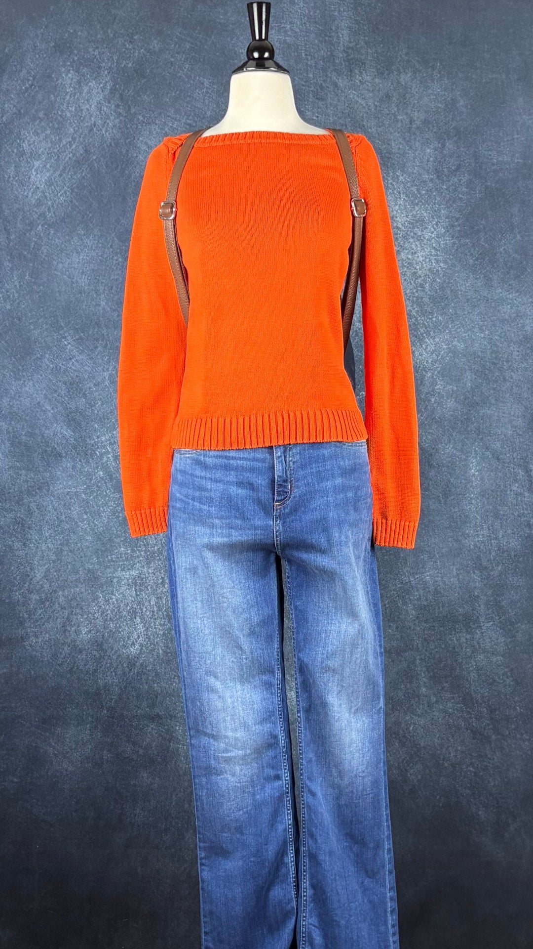 Jeans évasé coupe style bootcut, délavage bleu moyen, Yoga Jeans, taille 27. Vue de l'agencement avec le tricot de coton orange et le sac à dos Vera Pelle.
