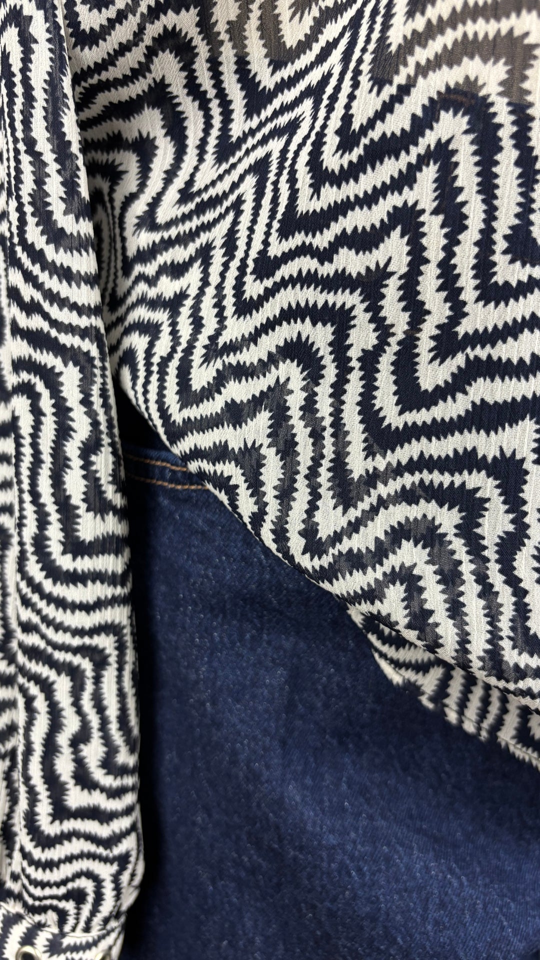 Jeans foncé modèle Uma galbé de Denim Forum, taille 29. Vue de près de l'agencement avec la blouse zigzag Scotch & Soda.