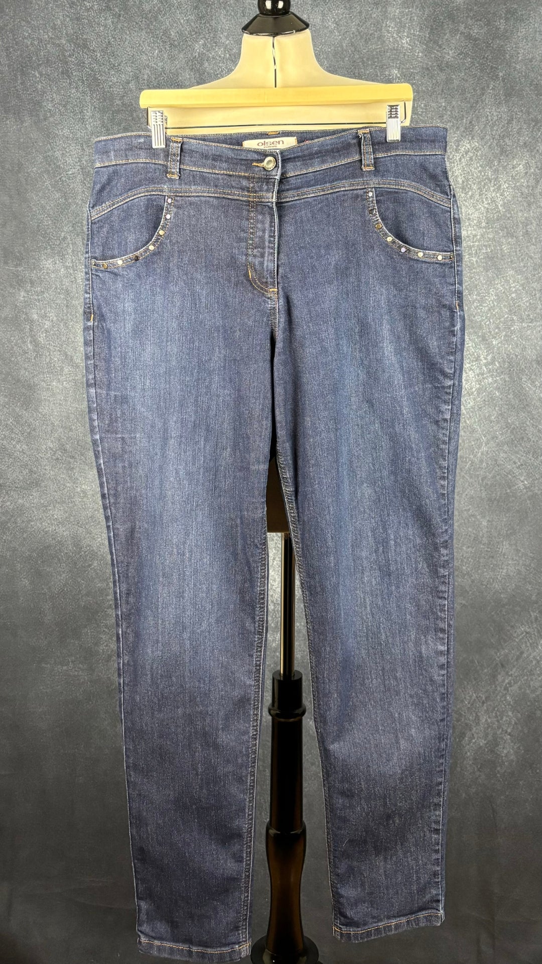 Jeans foncé jambe droite Olsen, taille 16 (xl). Vue de face, sur un cintre.