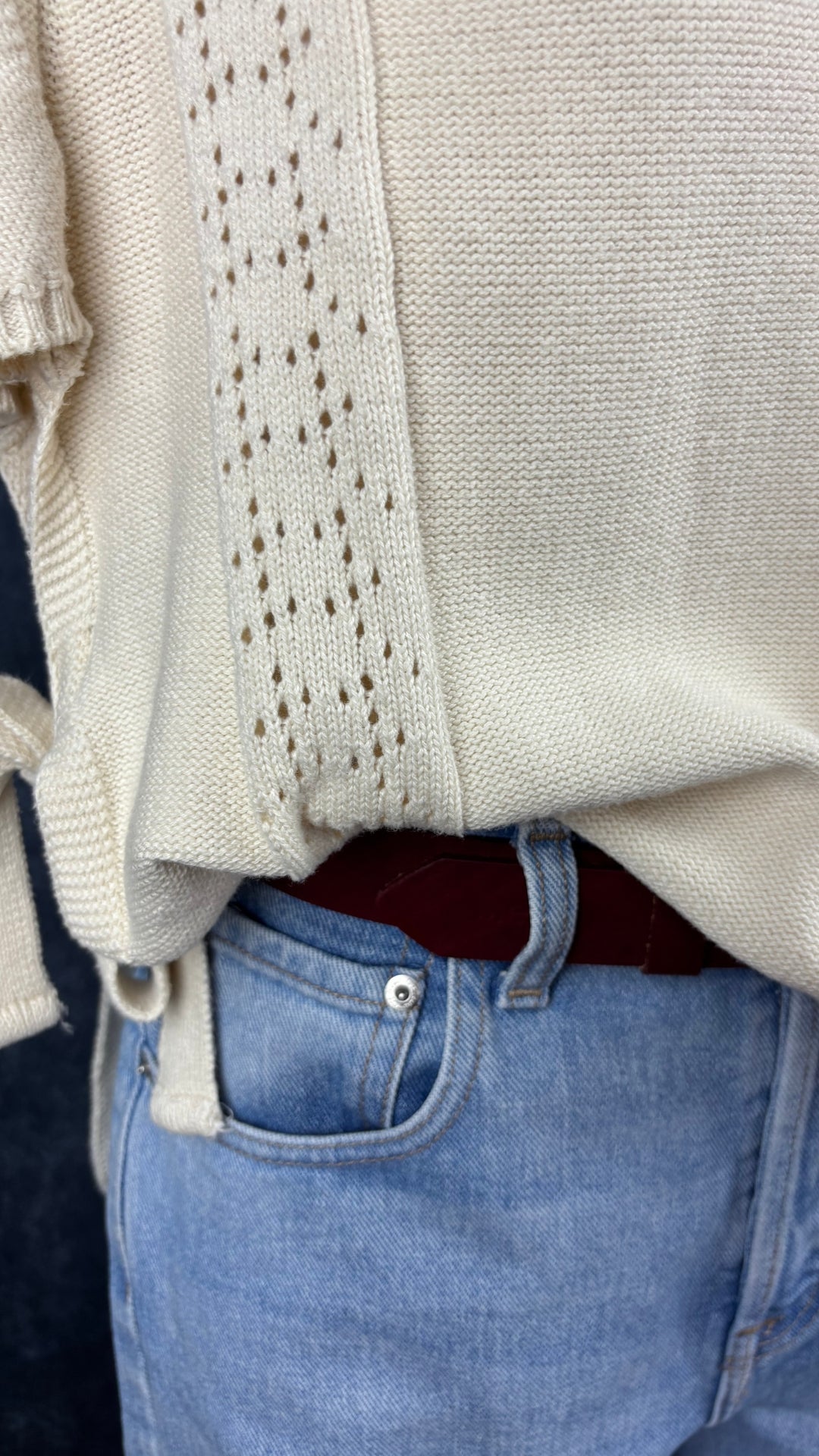 Jeans pâle à braguette boutonnée coupe droite légèrement ballon, Yoga Jeans, taille 28. Vue de près de l'agencement avec la ceinture bordeaux et le chandail tricot de coton Dailystory.