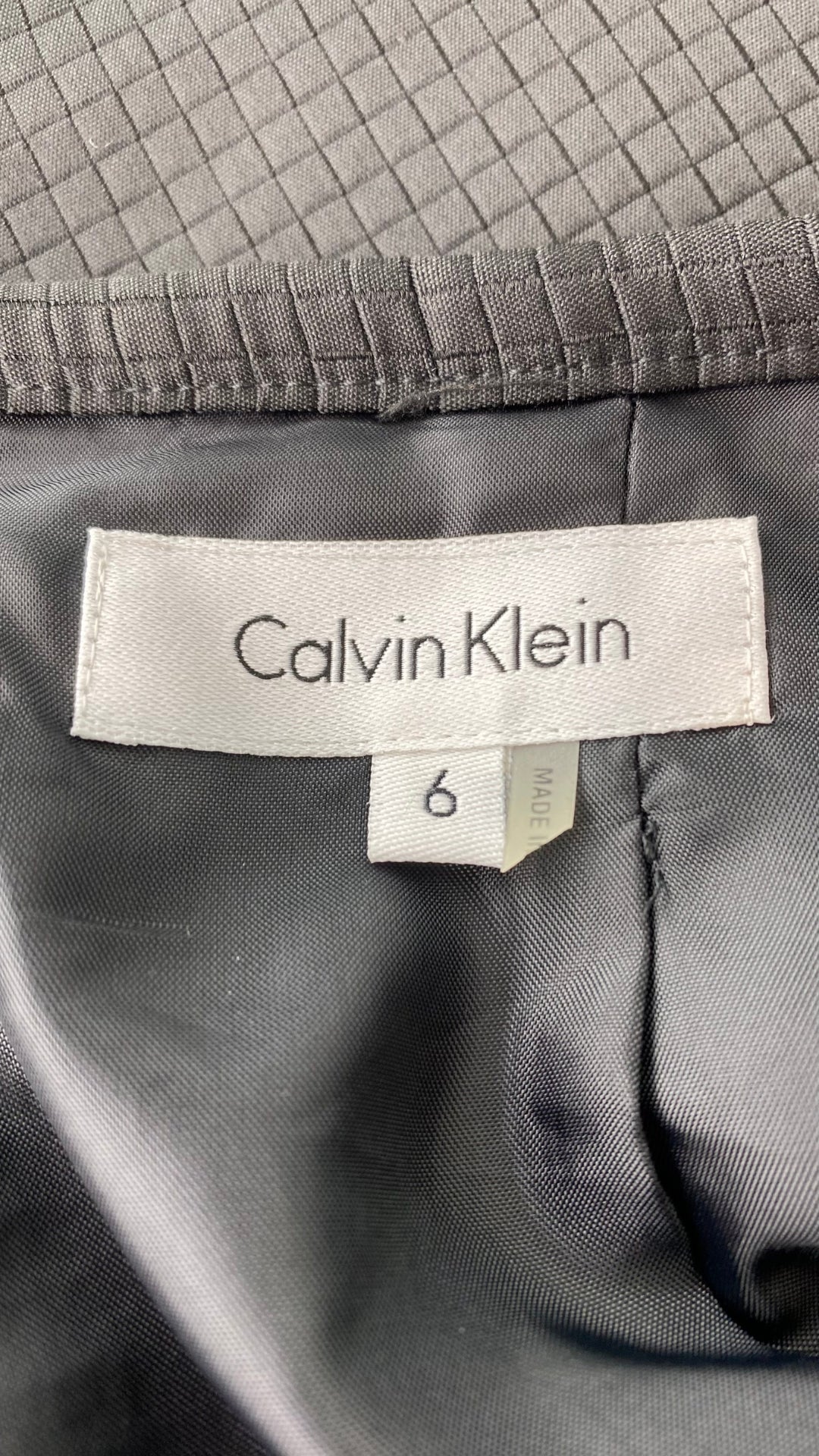 Jupe crayon noire texturée Calvin Klein, taille 6. Vue de l'étiquette de marque et taille.