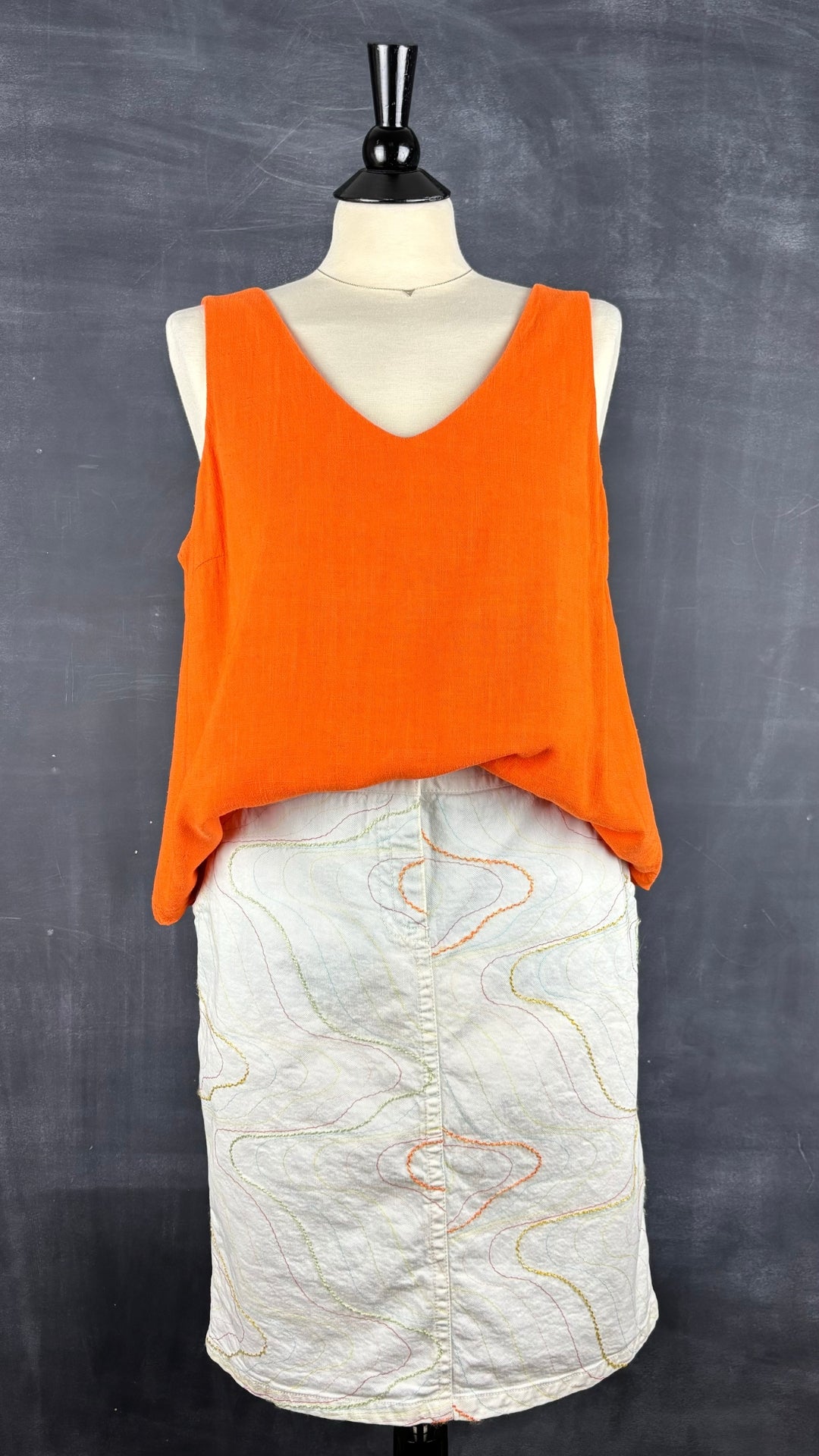 Jupe crème à broderies colorées Jocavi, taille 30 (medium). Vue de l'agencement avec la camisole orange en mélange de lin.