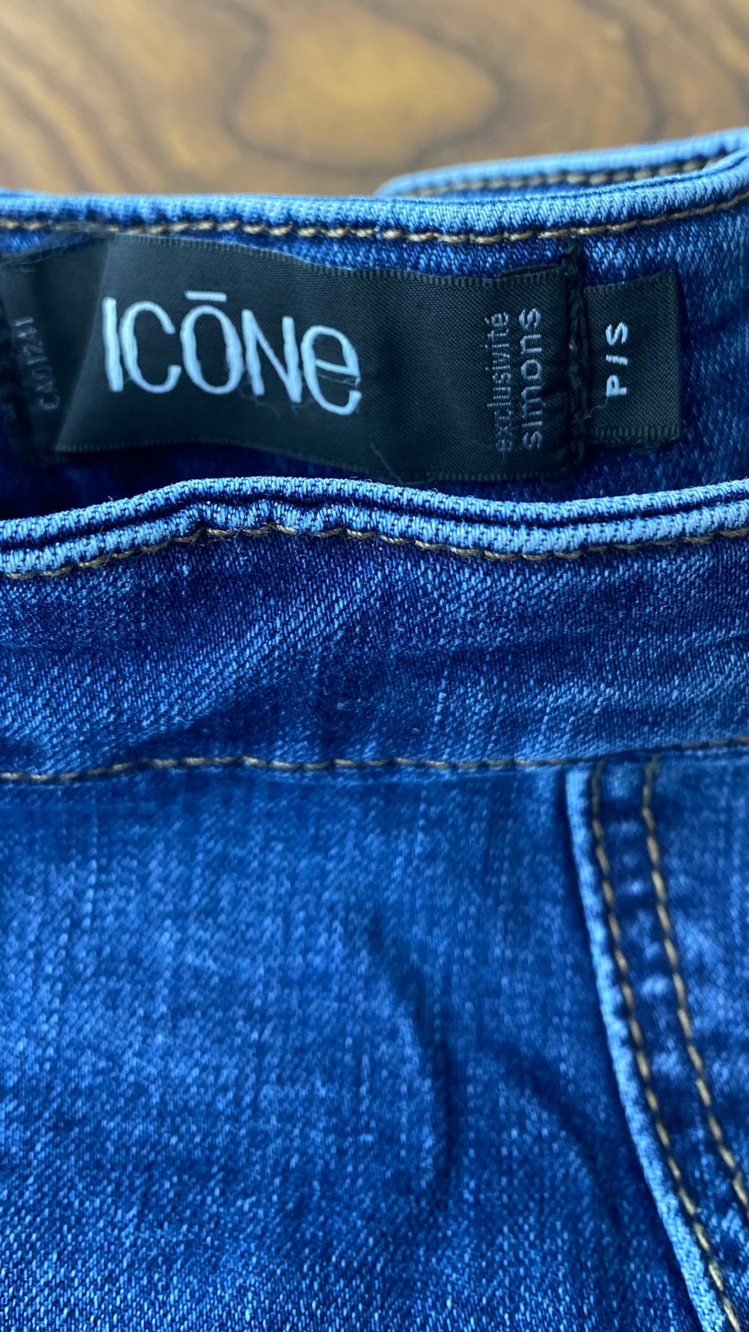 Jupe seconde main en jeans ligne A. Marque Icône par Simons, taille small. Vue de l'étiquette de marque et taille.