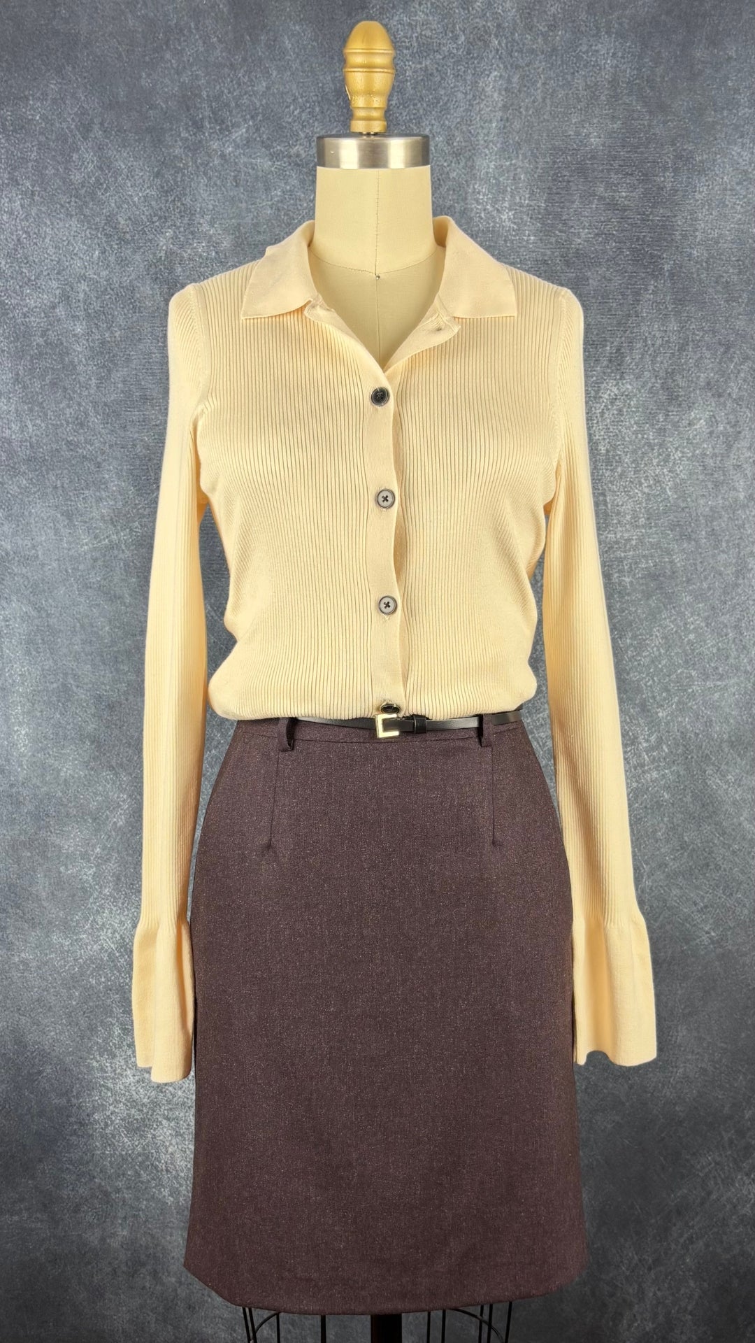 Jupe en lainage aubergine foncée Theory, taille 2. Vue de l'agencement avec le cardigan crème InWear et une fine ceinture.