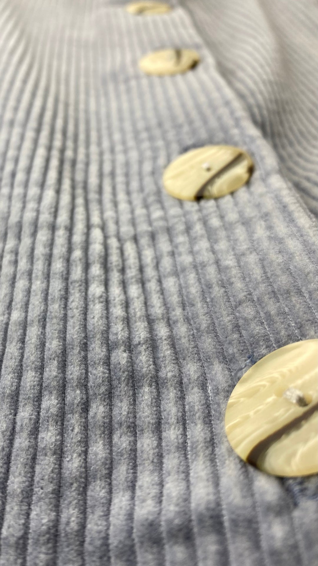 Jupe midi boutonnée gris-bleu en velours côtelé Essentiels &Co, taille small (xs). Vue de près des boutons, tissu.