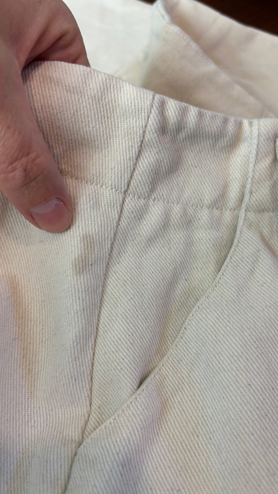 Jupe midi crème avec longue fermeture à glissière centrale à double curseur Harly Jae, taille medium. Vue de la petite tache près de la bande de taille, au dos.