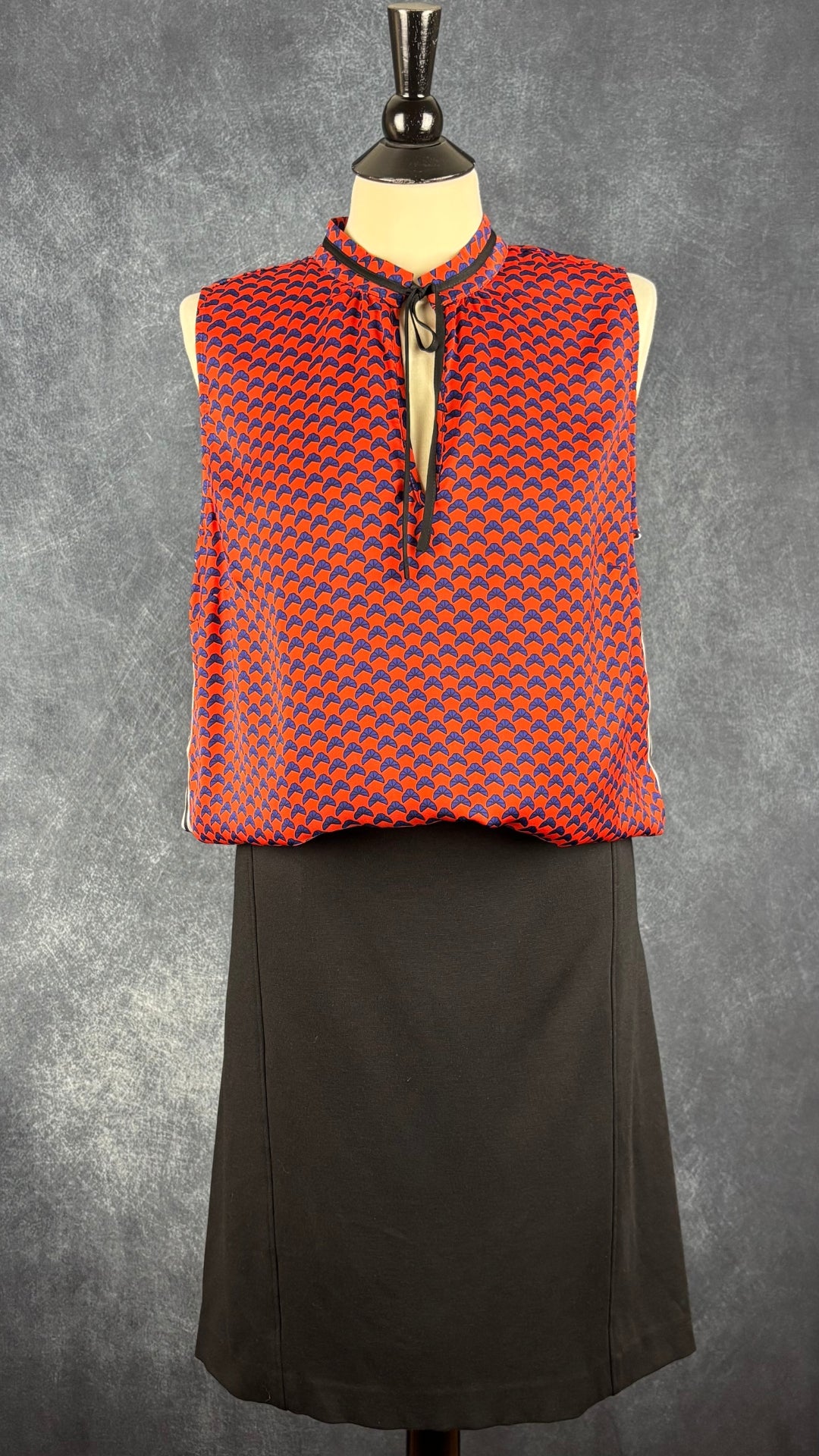 Jupe noire simple parfaite pour voyager Tilley, taille 14. Vue de l'agencement avec la camisole orangé/rouge Tristan.