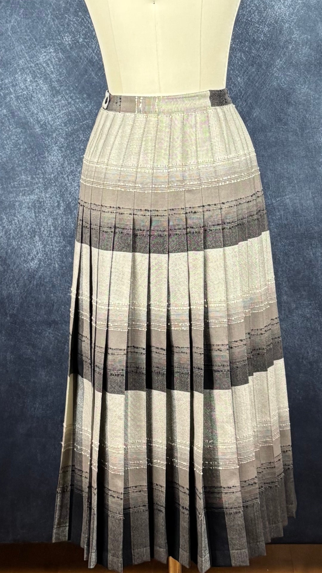 Jupe plissée vintage à carreaux réversible en laine Highland Queen, taille estimée à xs. Vue de face, la jupe du côté beige/taupe.