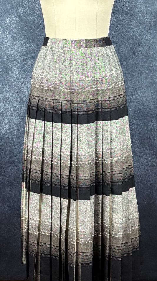 Jupe plissée vintage à carreaux réversible en laine Highland Queen, taille estimée à xs. Vue de la jupe sur le mannequin côté plus noir/gris.