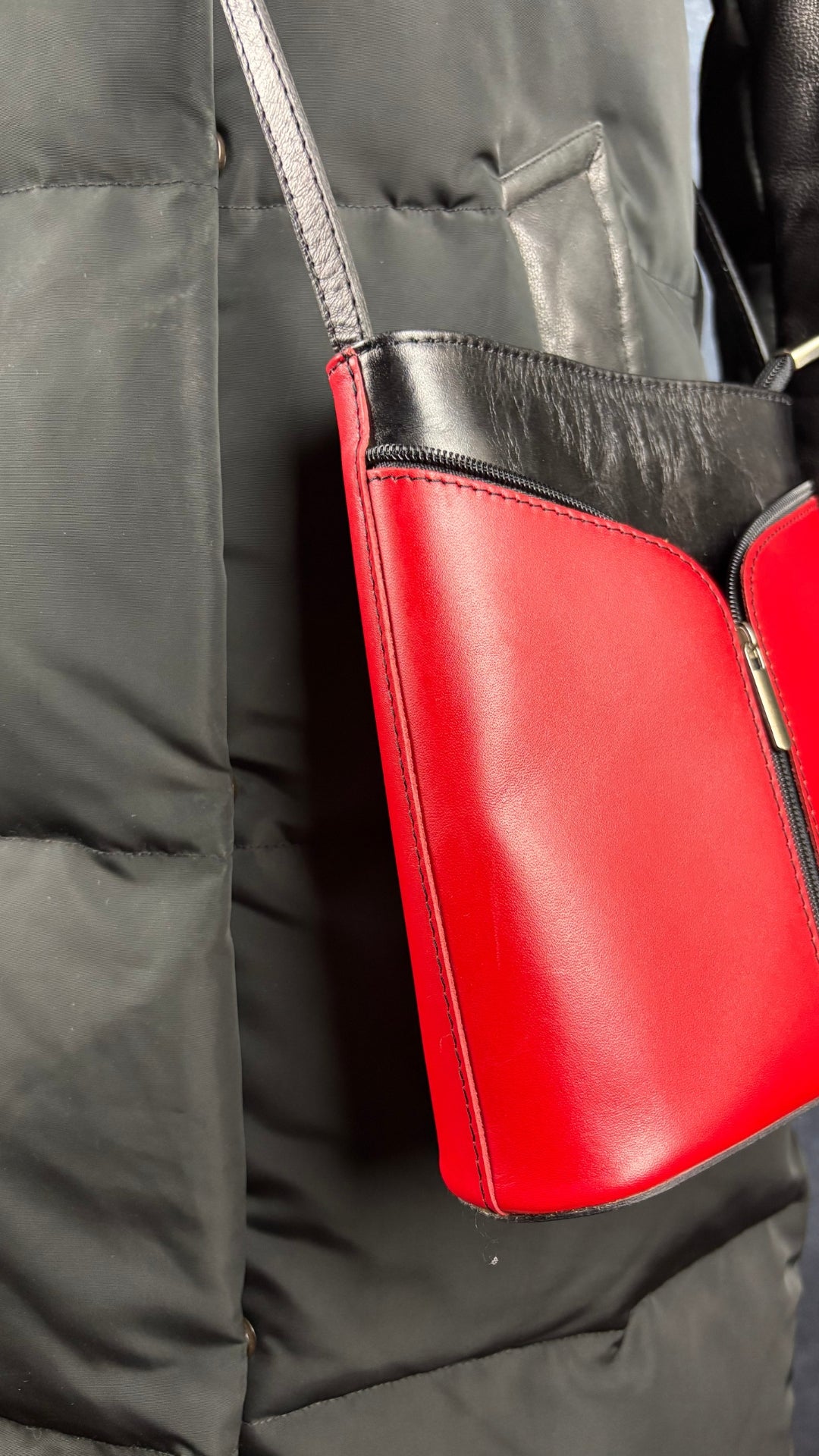 Manteau isolé en duvet mi-long noir avec détails en cuir, Rudsak, taille xs qui fait aussi small. Vue de près de l'agencement avec le sac à main en cuir rouge et noir.
