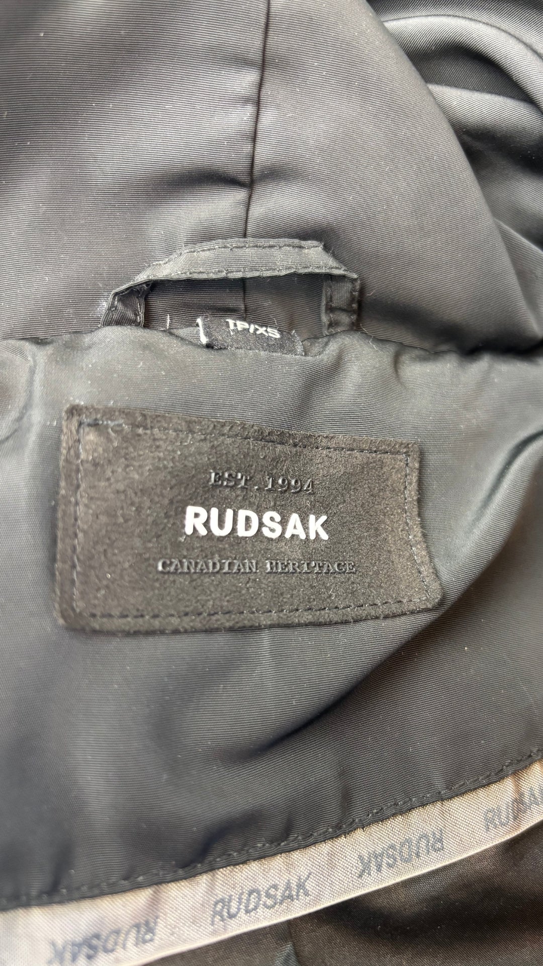 Manteau isolé en duvet mi-long noir avec détails en cuir, Rudsak, taille xs qui fait aussi small. Vue de l'étiquette.