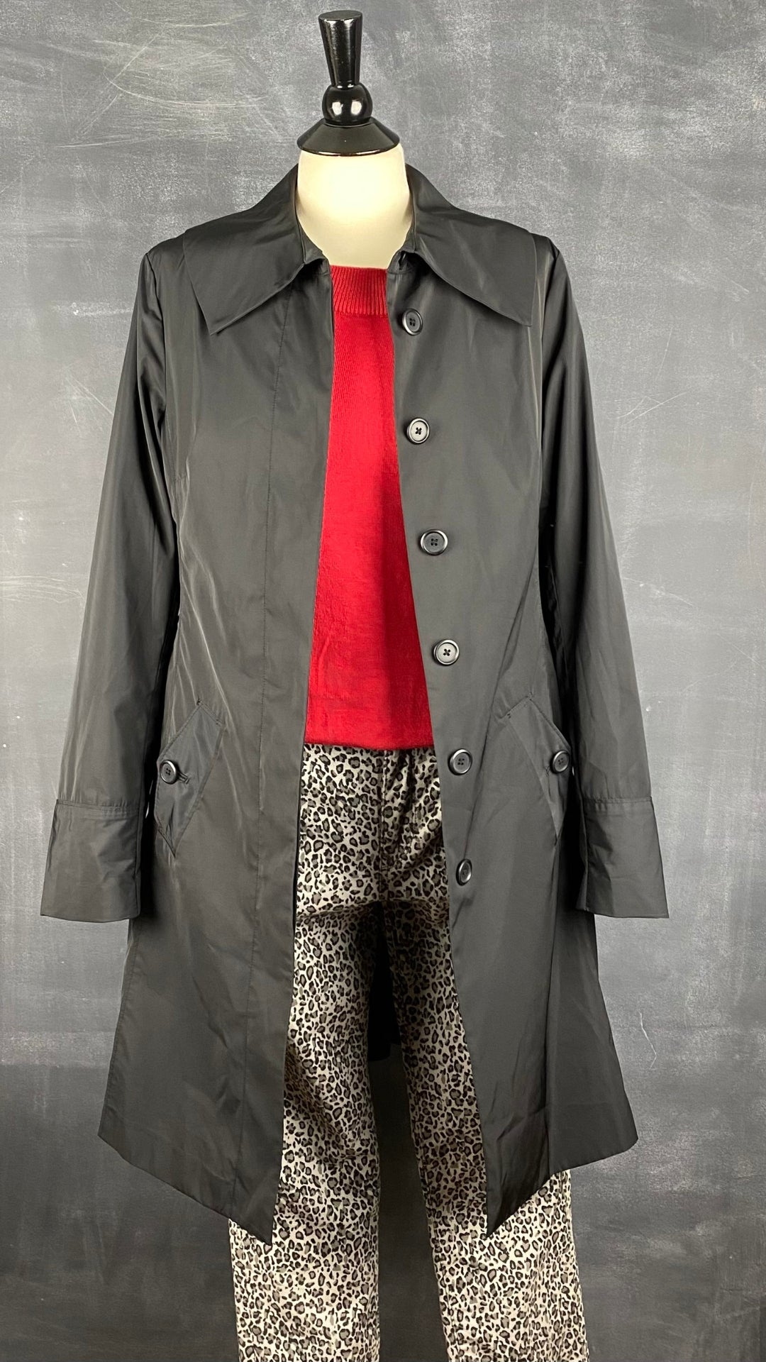 Manteau noir printanier Tristan, taille s/m. Vue de l'agencement avec un tricot rouge et un pantalon léopard.