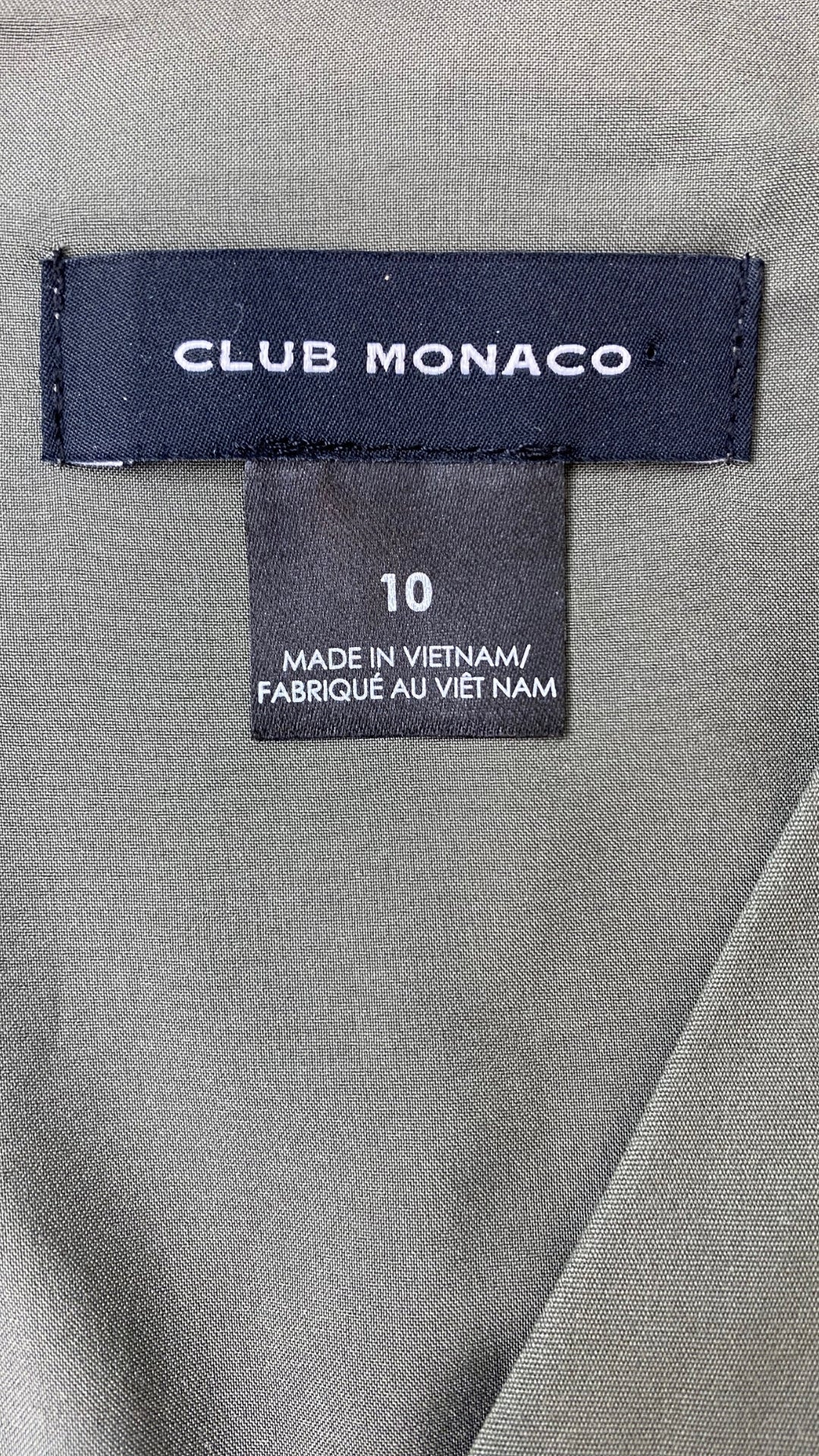 Haut peplum kaki doux Club Monaco, taille 10. Vue de l'étiquette de marque et taille.