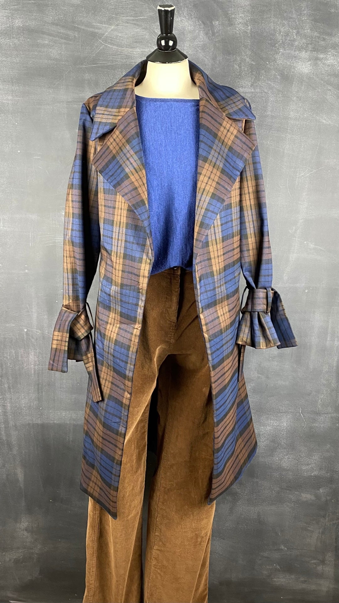 Pantalon fin velours côtelé acajou Woolrich, taille 6. Vue de l'agencement avec tricot laine de mérinos bleu et le manteau style trench à carreaux.