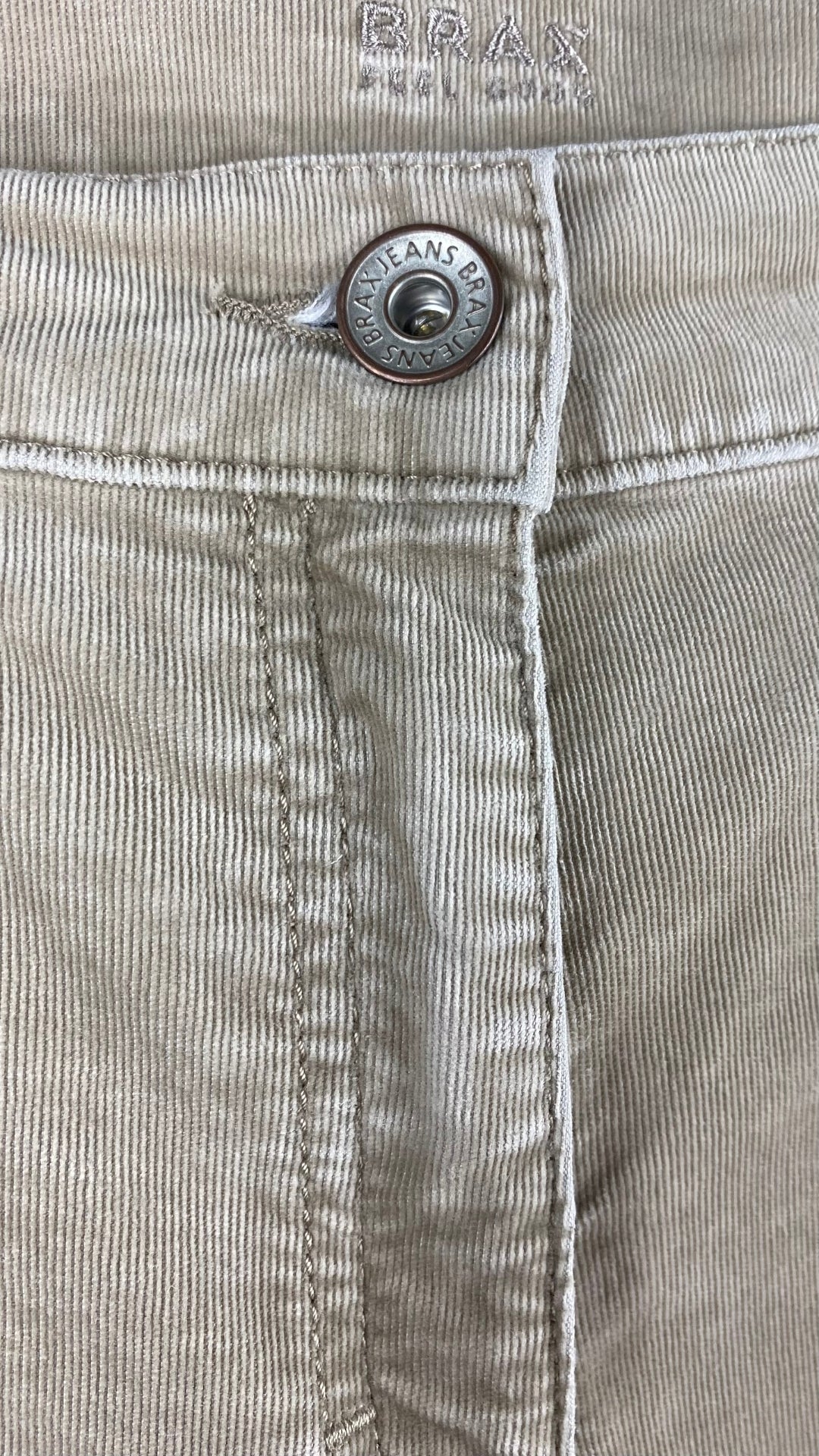 Pantalon en fin velours côtelé beige Brax, taille 31. Vue de près du bouton.