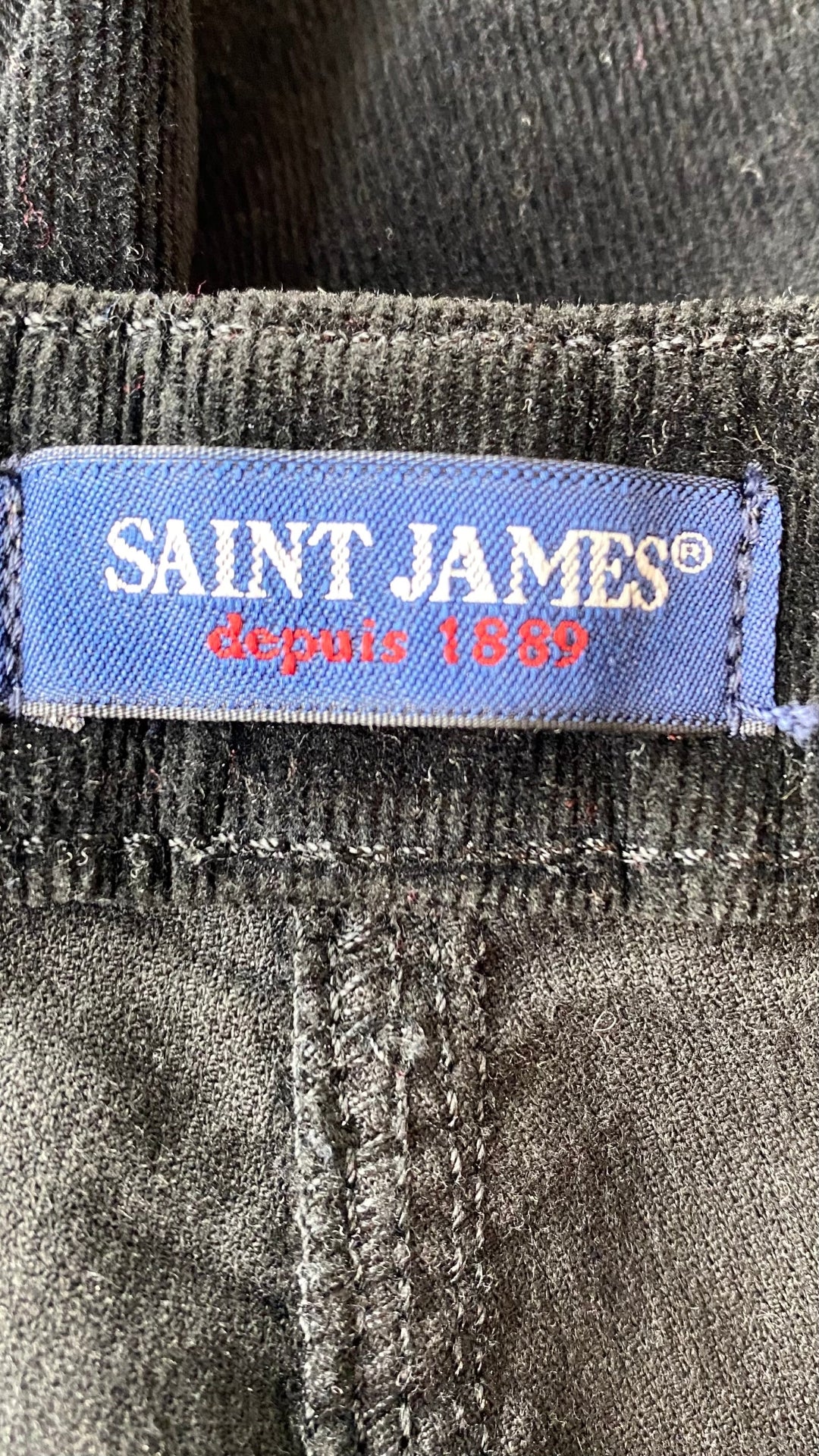 Pantalon en fin velours côtelé noir à jambes larges Saint-James, taille 14. Vue de l'étiquette de marque.