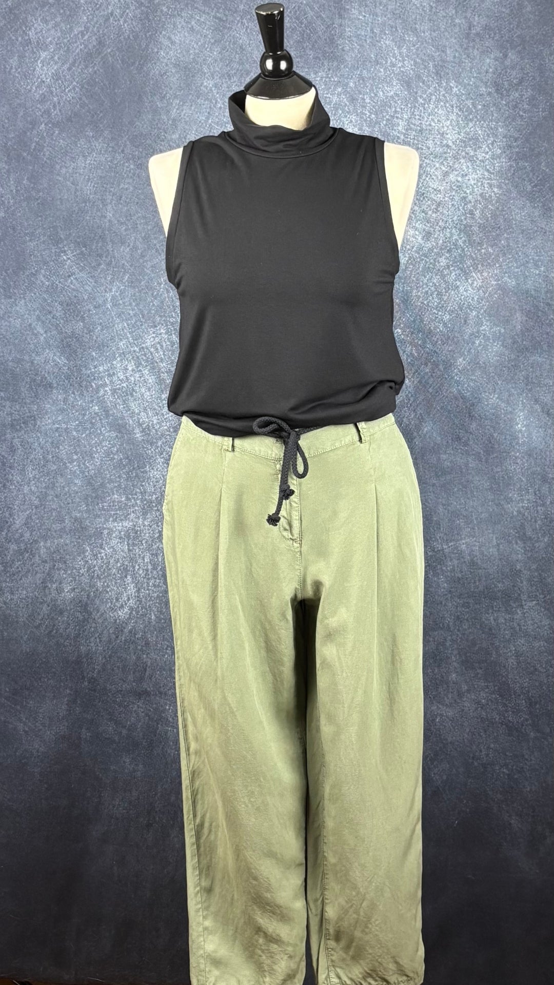 Pantalon léger vert olive écourté modèle Lisa, de Olsen, taille estimée à m/l. Vue de l'agencement avec la camisole noire à col montant Joelle.