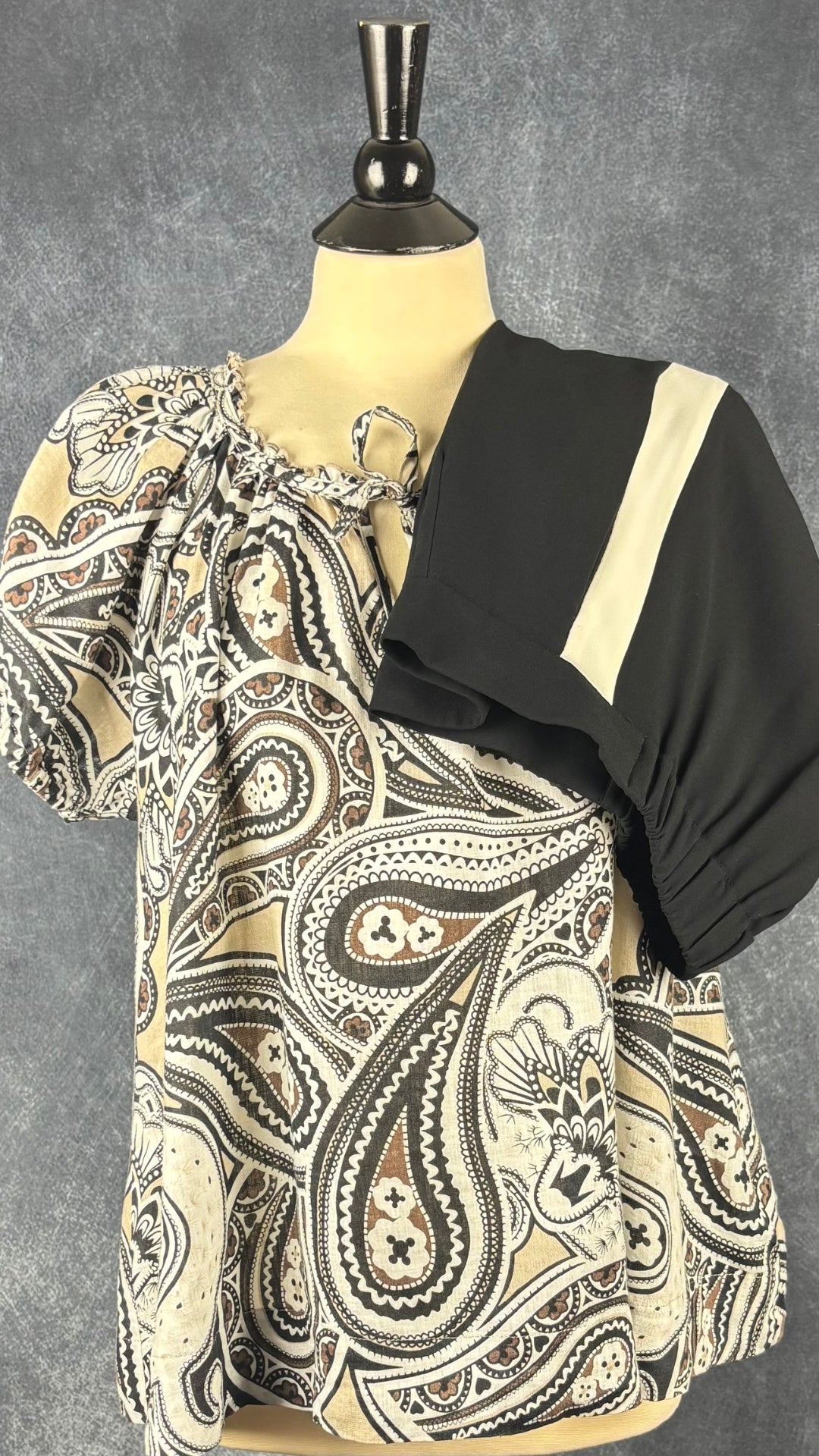 Pantalon noir court avec bandes lisérées crème sur les côtés Babaton, taille 2. Vue de l'agencement avec la blouse à motifs Part Two.