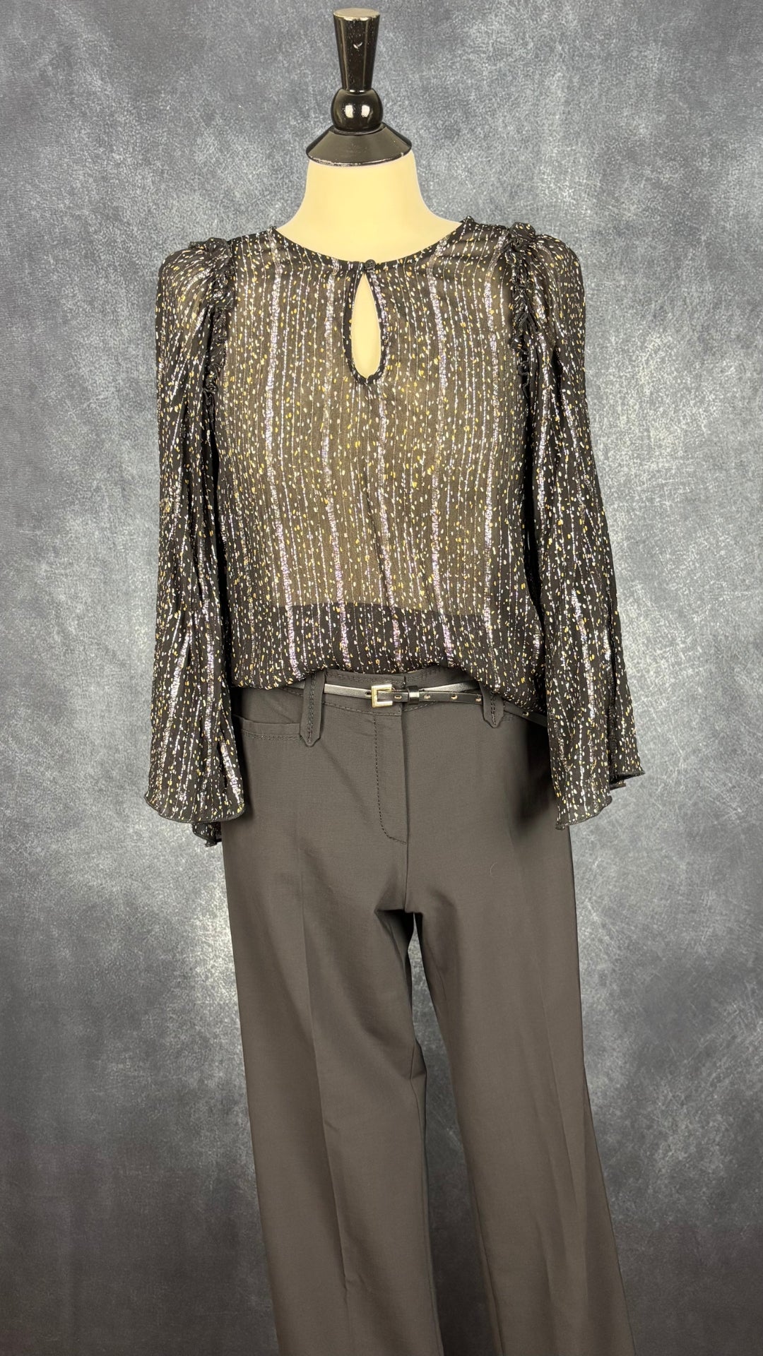 Pantalon noir à jambe droite Brax modèle Rita, taille 29. Vue de l'agencement avec la blouse transparente noire avec détails argent et or InWear.