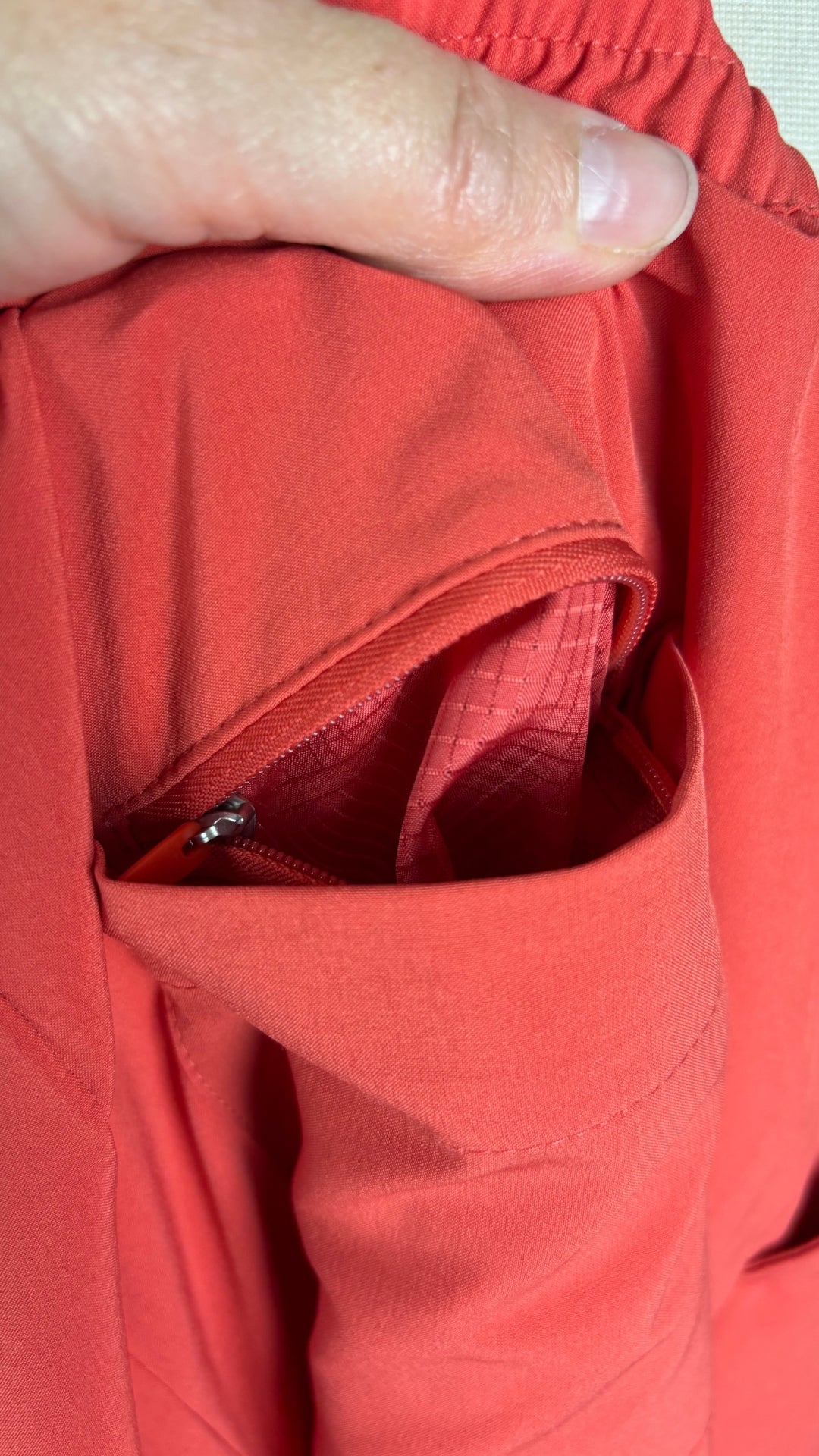 Pantalon orange doux en tissu léger parfait pour voyager Banana Republic Sport, taille small. Vue de la fermeture à glissière dans la poche arrière.