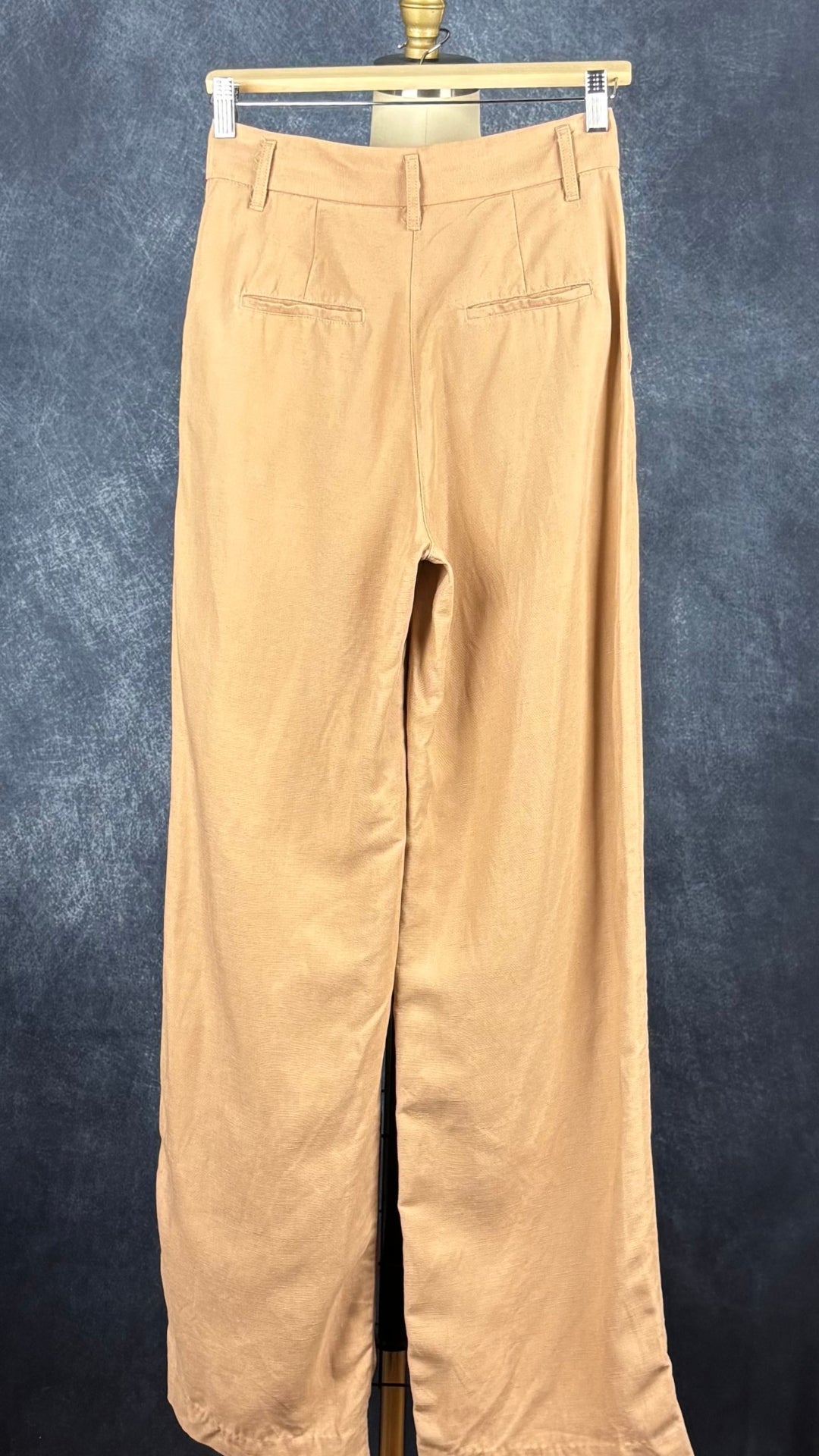 Pantalon à plis à jambe large beige tan en mélange de Lyocell et de lin, Wilfred, taille 2. Vue de dos, sur un cintre.