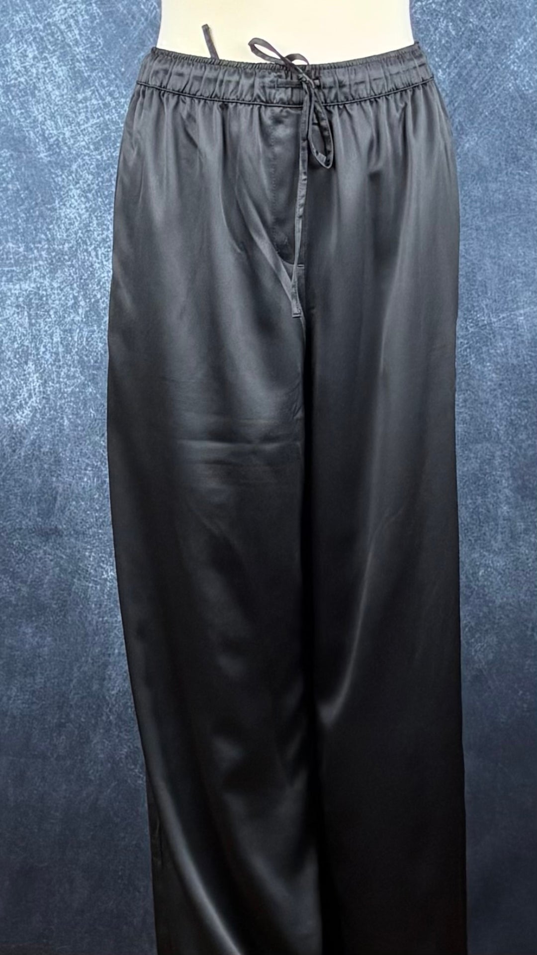 Pantalon satiné noir à jambes larges Calvin Klein, taille large. Vue de face, sur le mannequin.