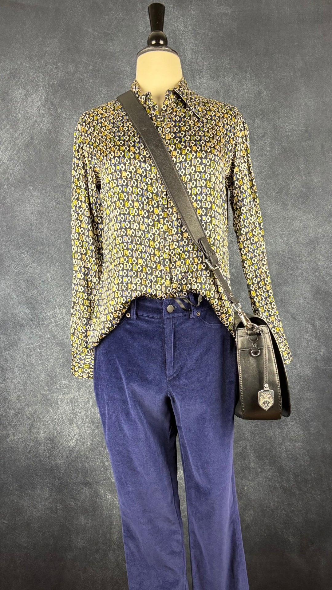 Pantalon en velours extensible bleu nuit Iris Setlakwe, taille 6. Vue de l'agencement avec le chemisier en soie à motifs et le sac à main Rudsak.