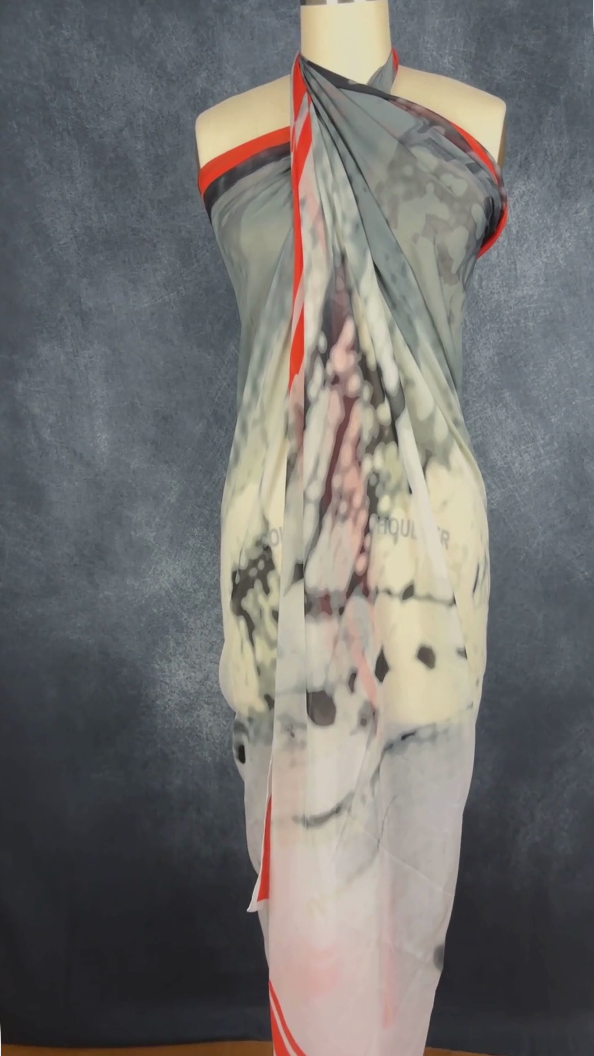 Grand foulard carré gris et orangé femme fatale. Vue de la vidéo qui présente tous les détails du foulard.