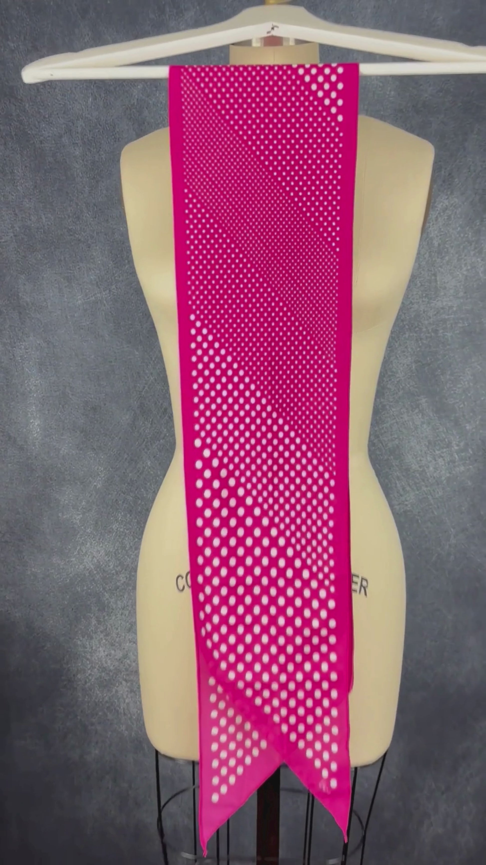 Foulard rose étroit à extrémités en pointe à pois blanc Vera. Vue de la vidéo qui présente tous les détails du foulard.
