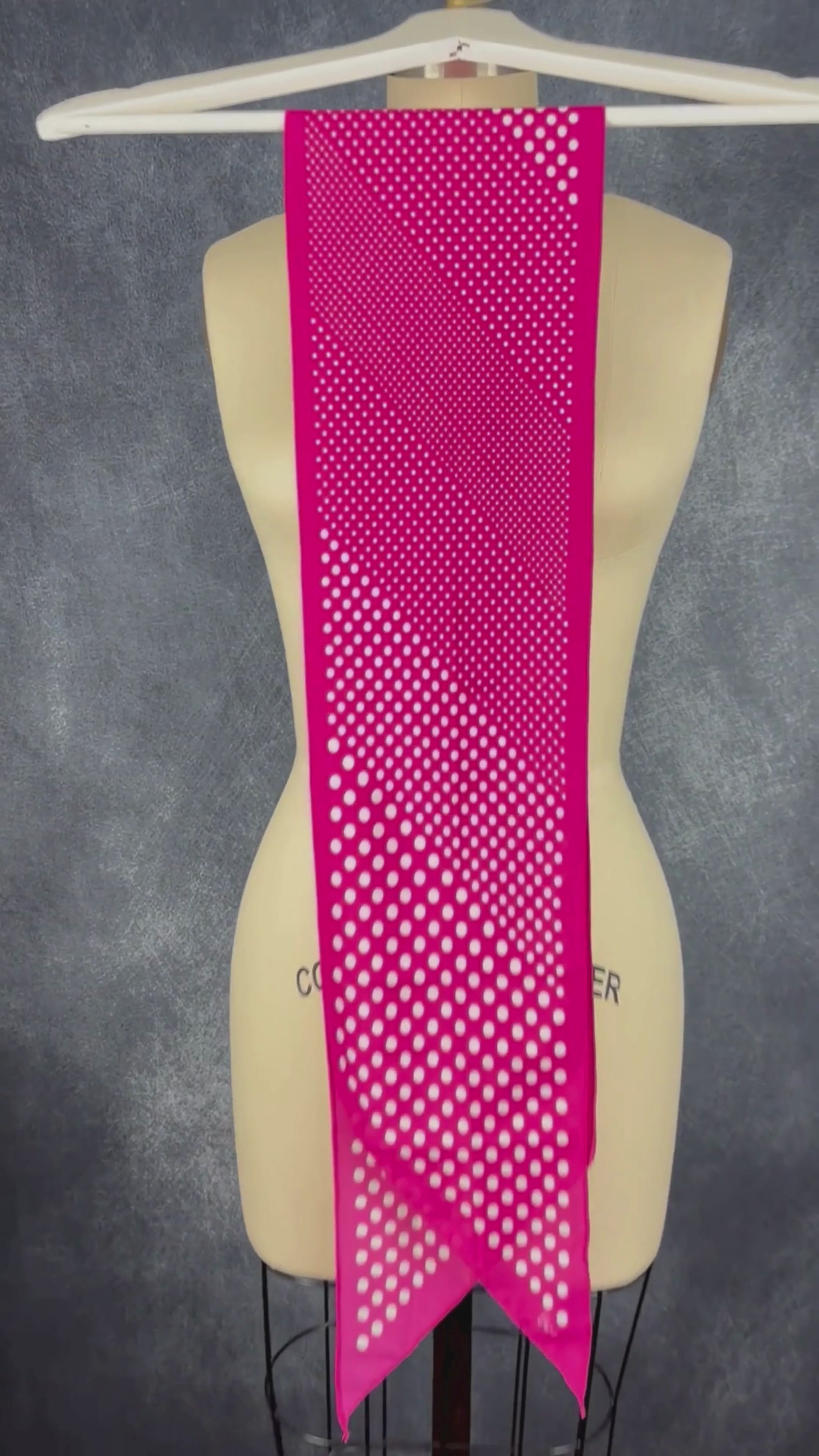 Foulard rose étroit à extrémités en pointe à pois blanc Vera. Vue de la vidéo qui présente tous les détails du foulard.