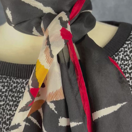 Foulard noir, blanc et rouge Monique Martin, rectangulaire long. Vue de la vidéo qui présente tous les détails du foulard.